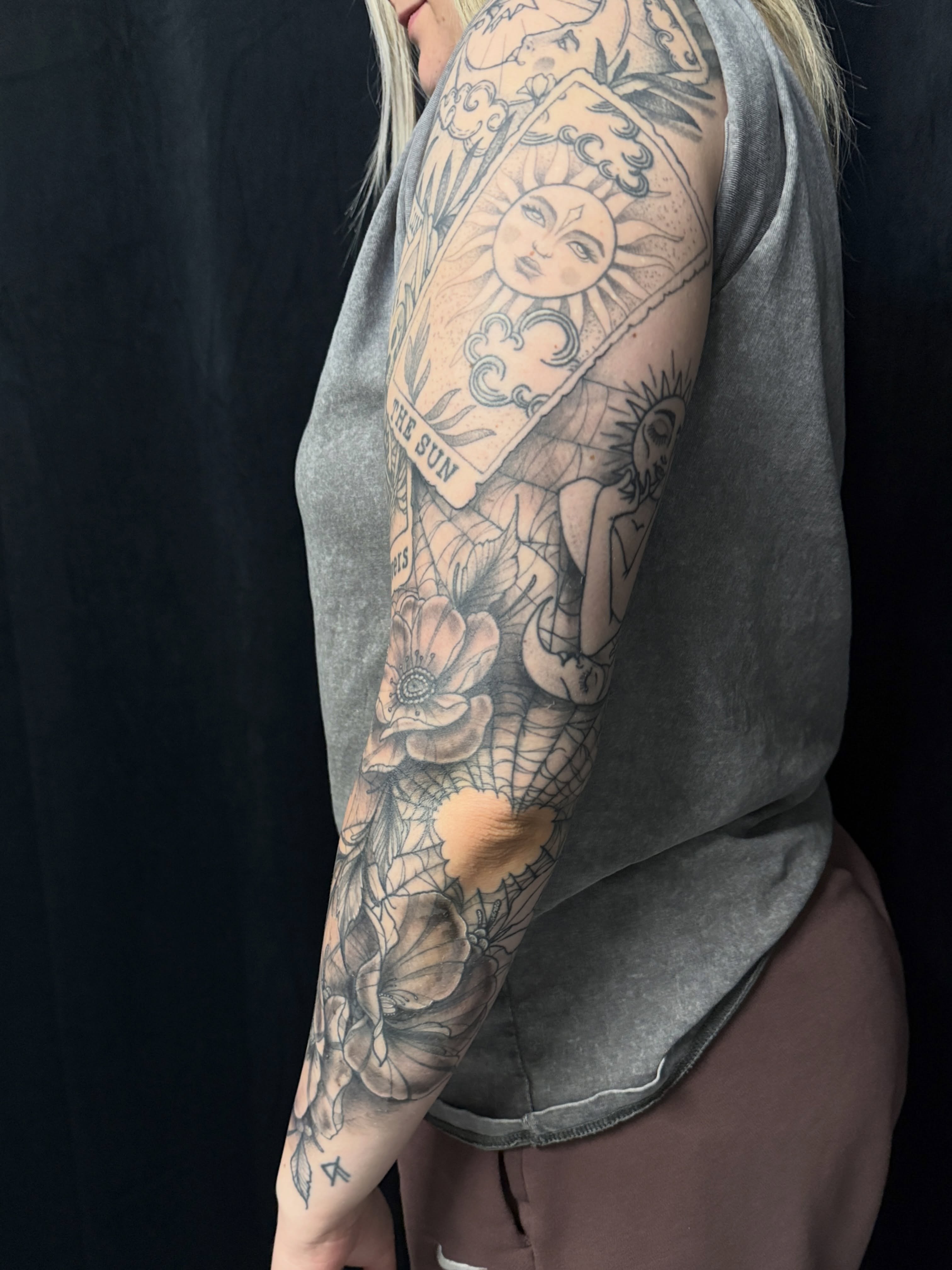 Sun and flowers black and grey tattoo on the upper arm by Will McCoy (Tattooist), Murray, Utah