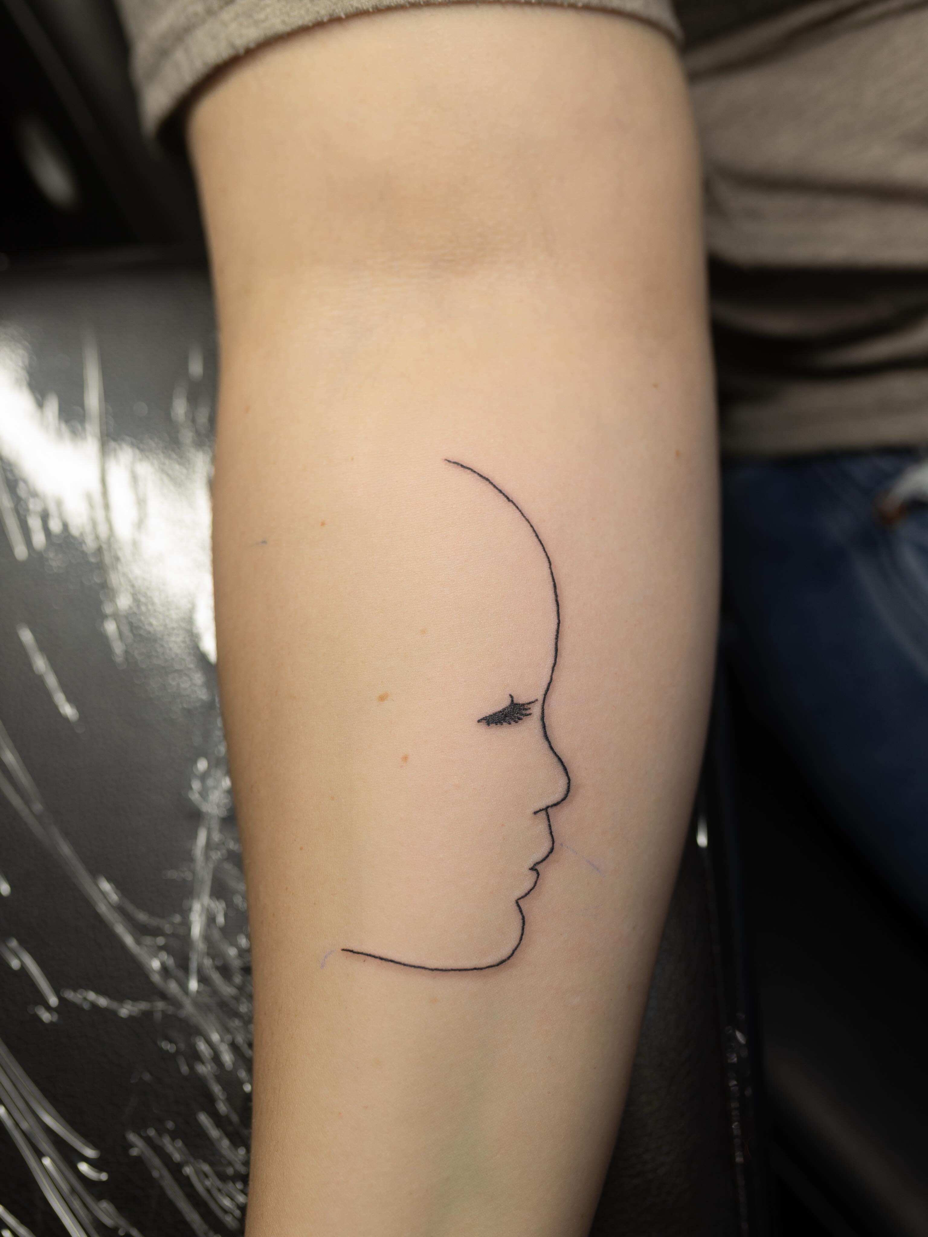 Profile silhouette minimalist tattoo on the forearm by Kelsie