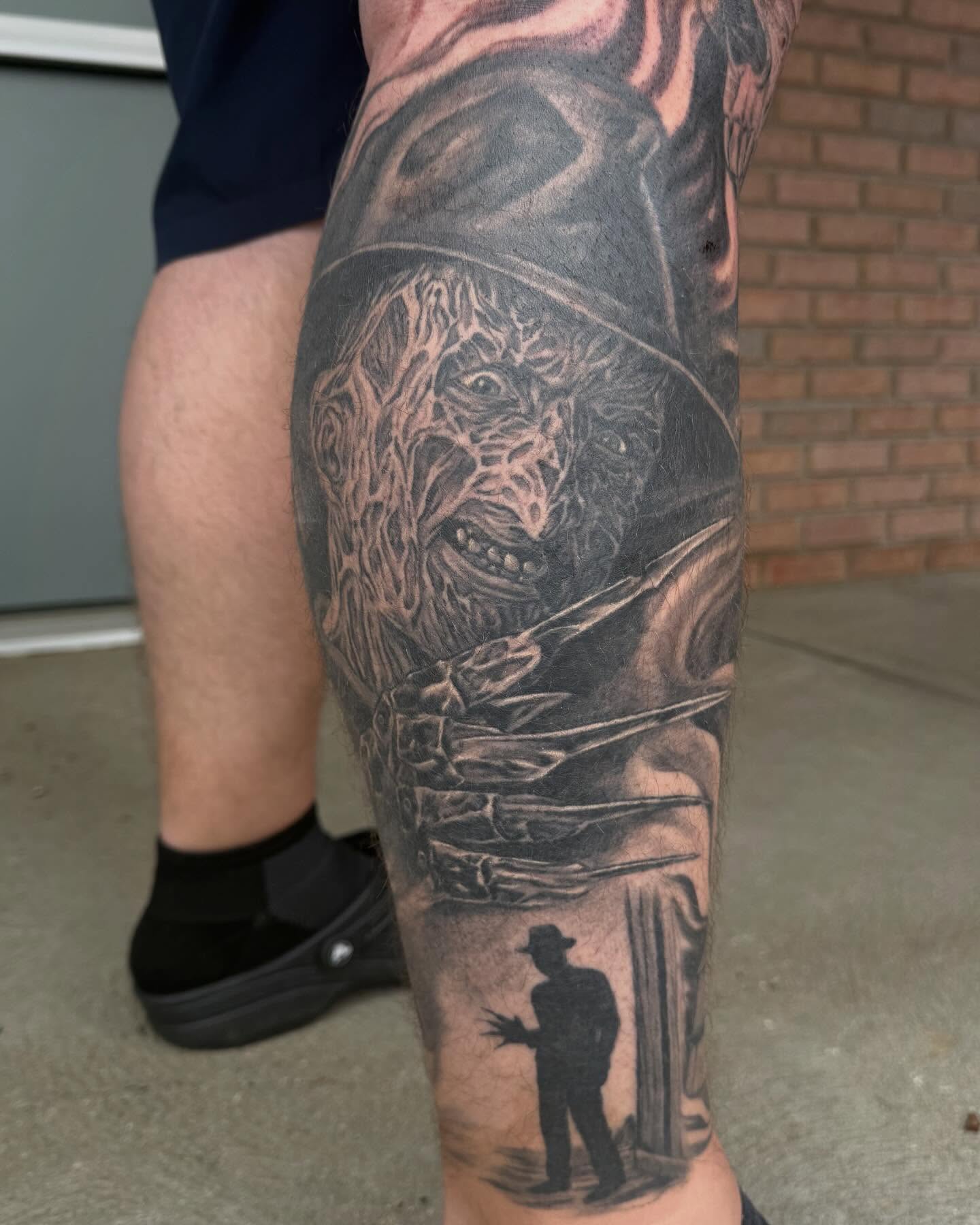 Horror movie character realism tattoo on the calf by Jesse Gray