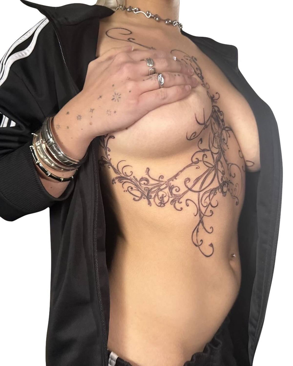 Scrollwork ornamental tattoo on the chest by Seattle Cybersigilism Tattoo Horror