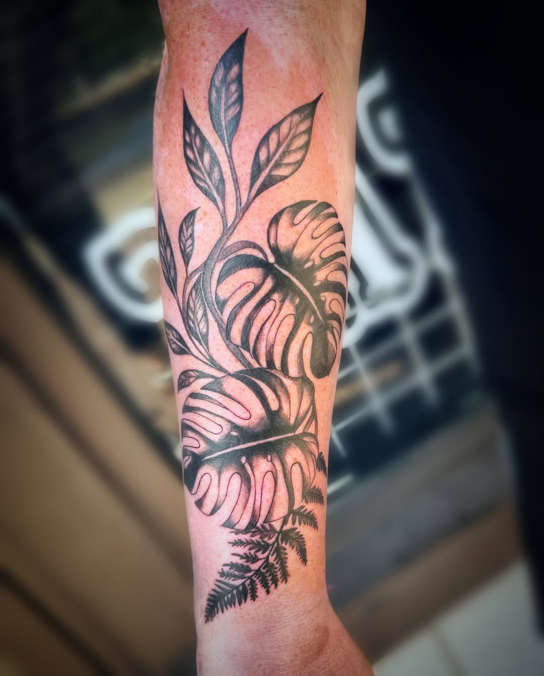 Monstera leaves and fern tribal tattoo on the forearm by Kate