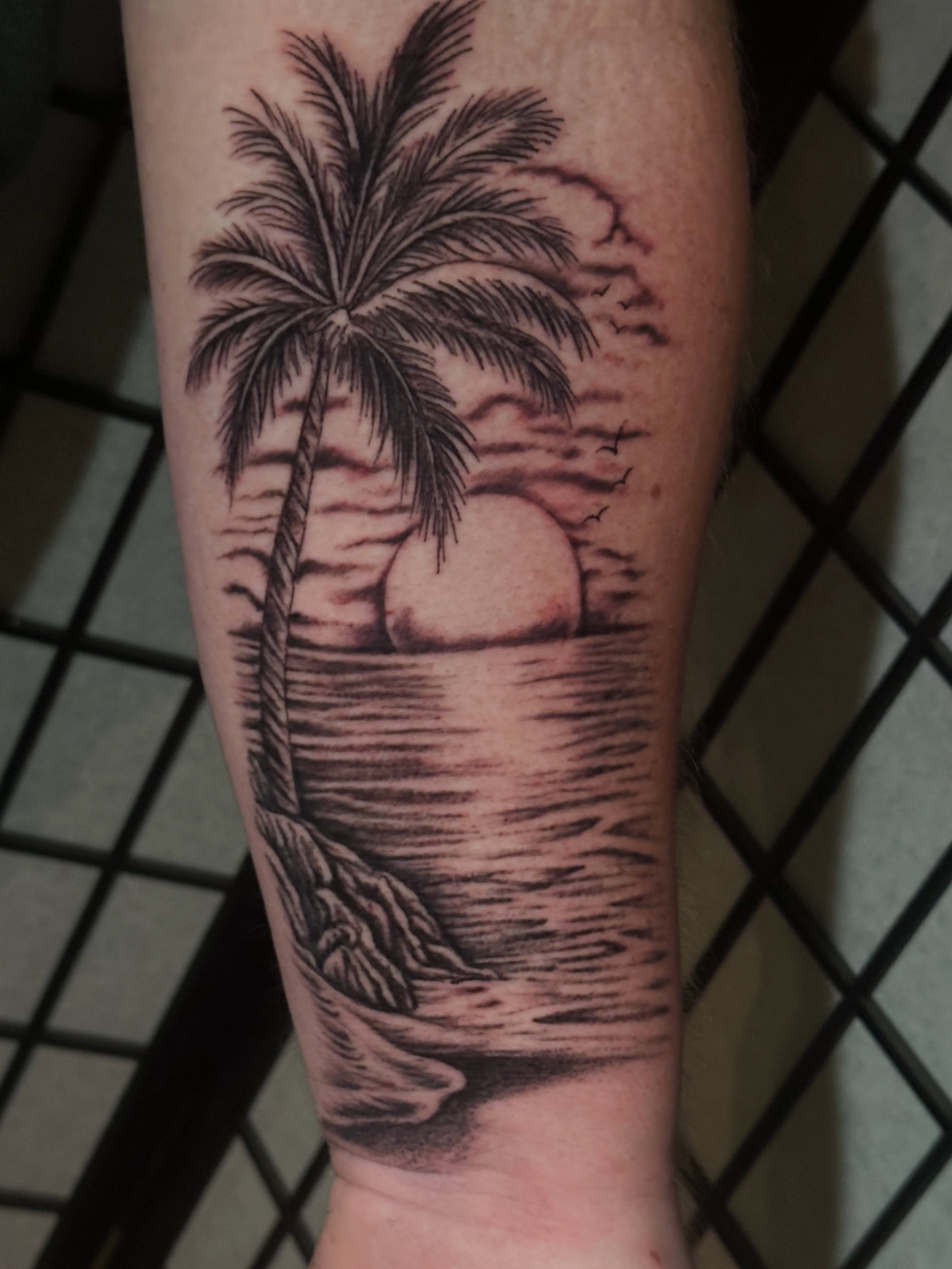 Palm tree sunset realism tattoo on the forearm by Chris Whittaker Tattoo Artist