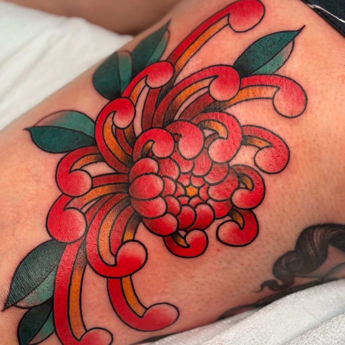 Chrysanthemum American traditional tattoo on the thigh by Nick Tate