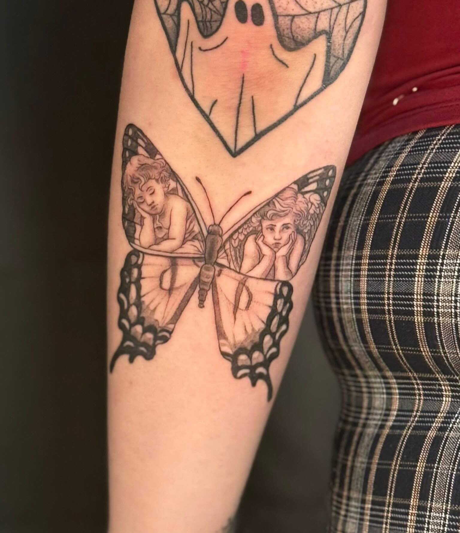 Butterfly with cherubs realism tattoo on the forearm by Olivia, Royal Oak, Michigan