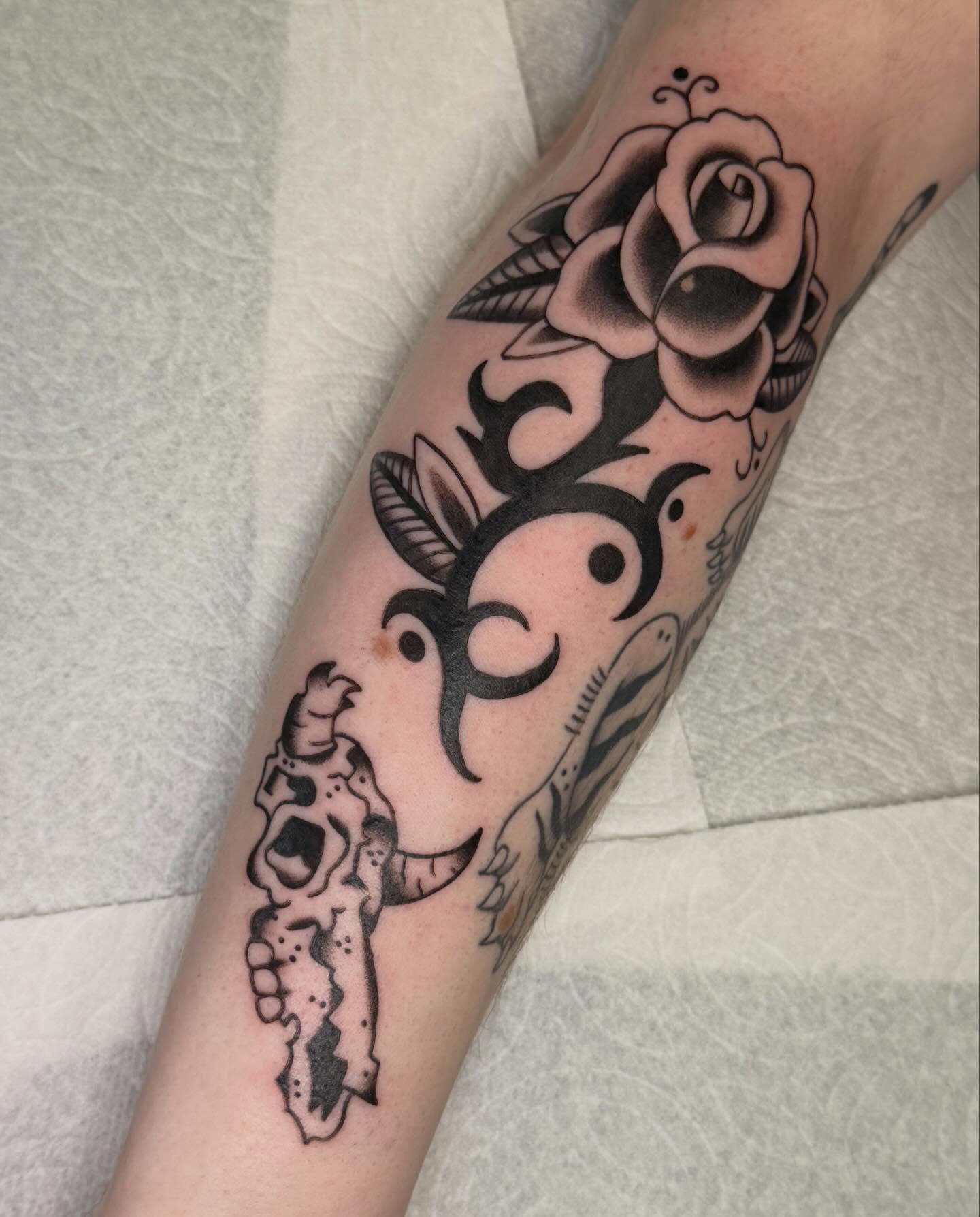 Rose and skull American traditional tattoo on the forearm by charlie
