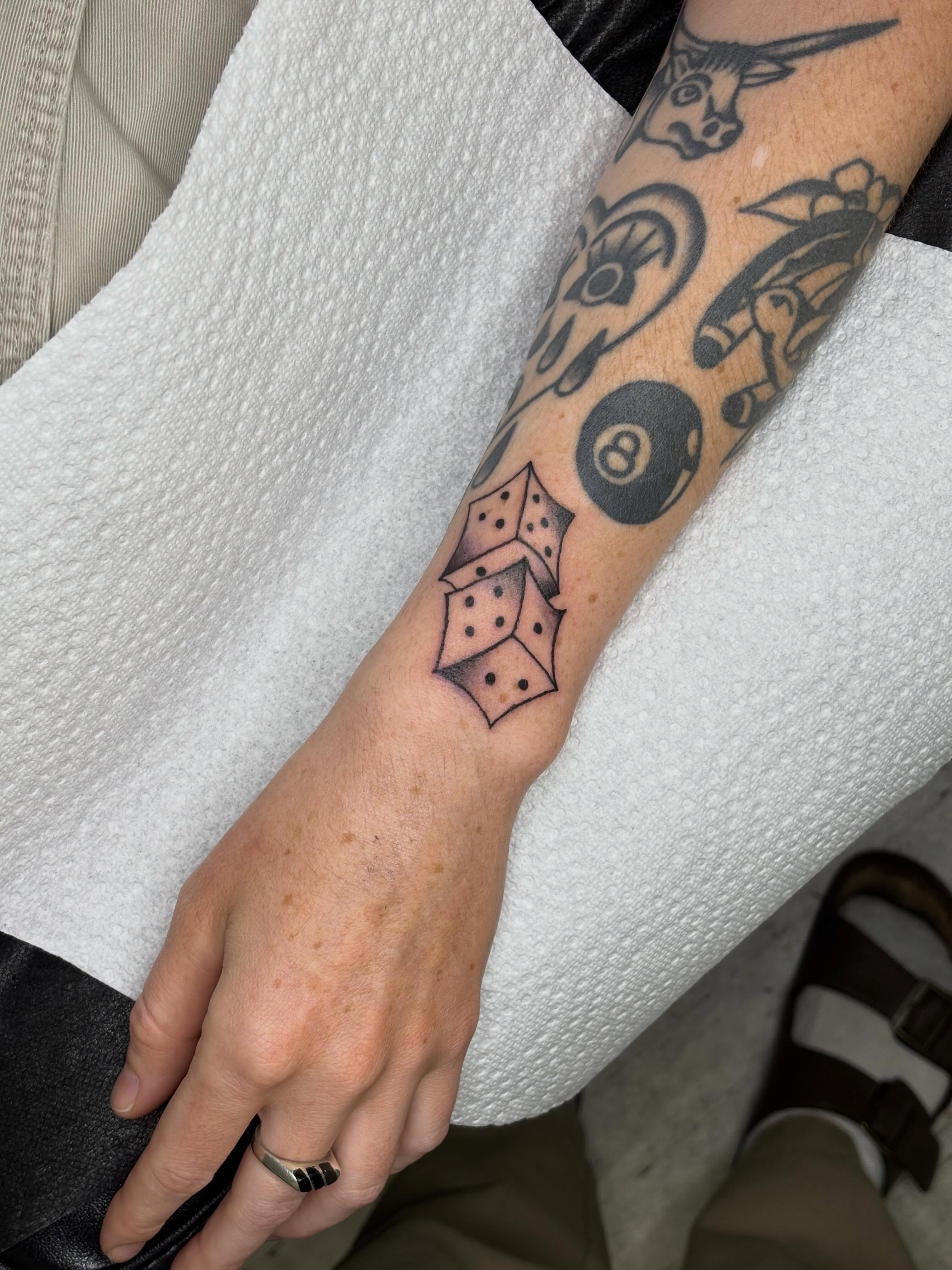 Dice black and grey tattoo on the forearm by Topher Belmont