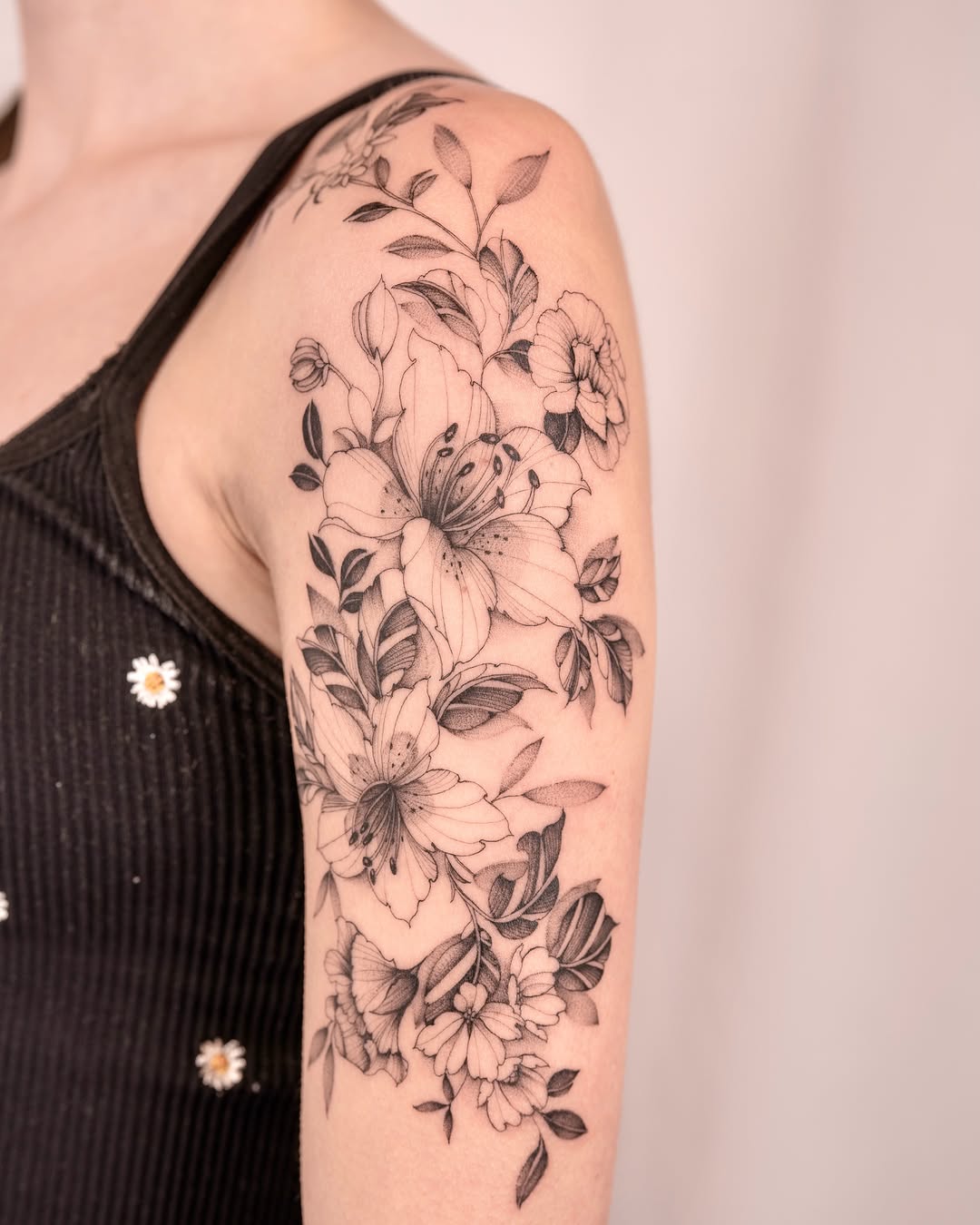 Floral bouquet black and grey tattoo on the upper arm by Leo Gao