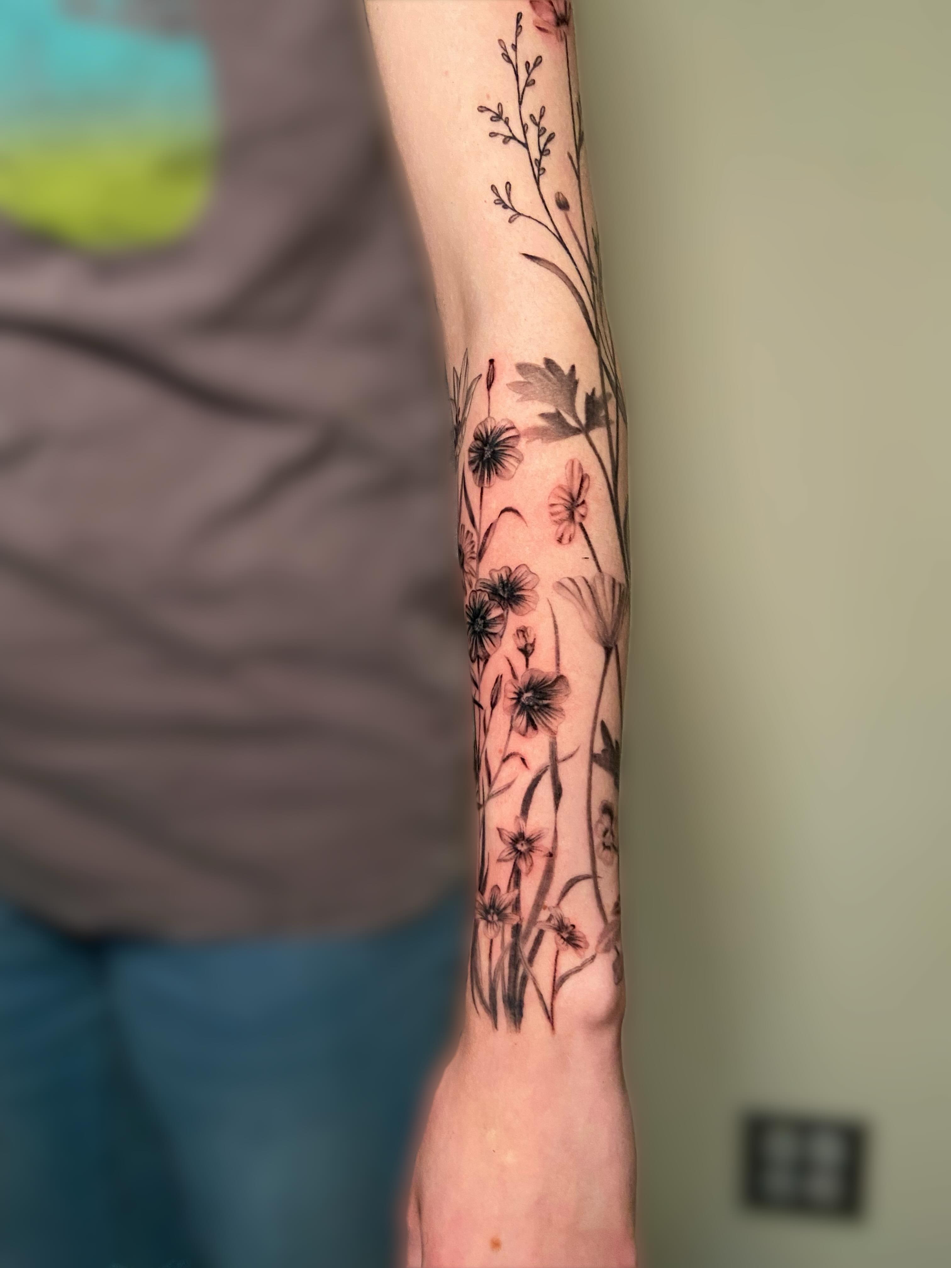 Floral arrangement black and grey tattoo on the forearm by Ezra Gonda