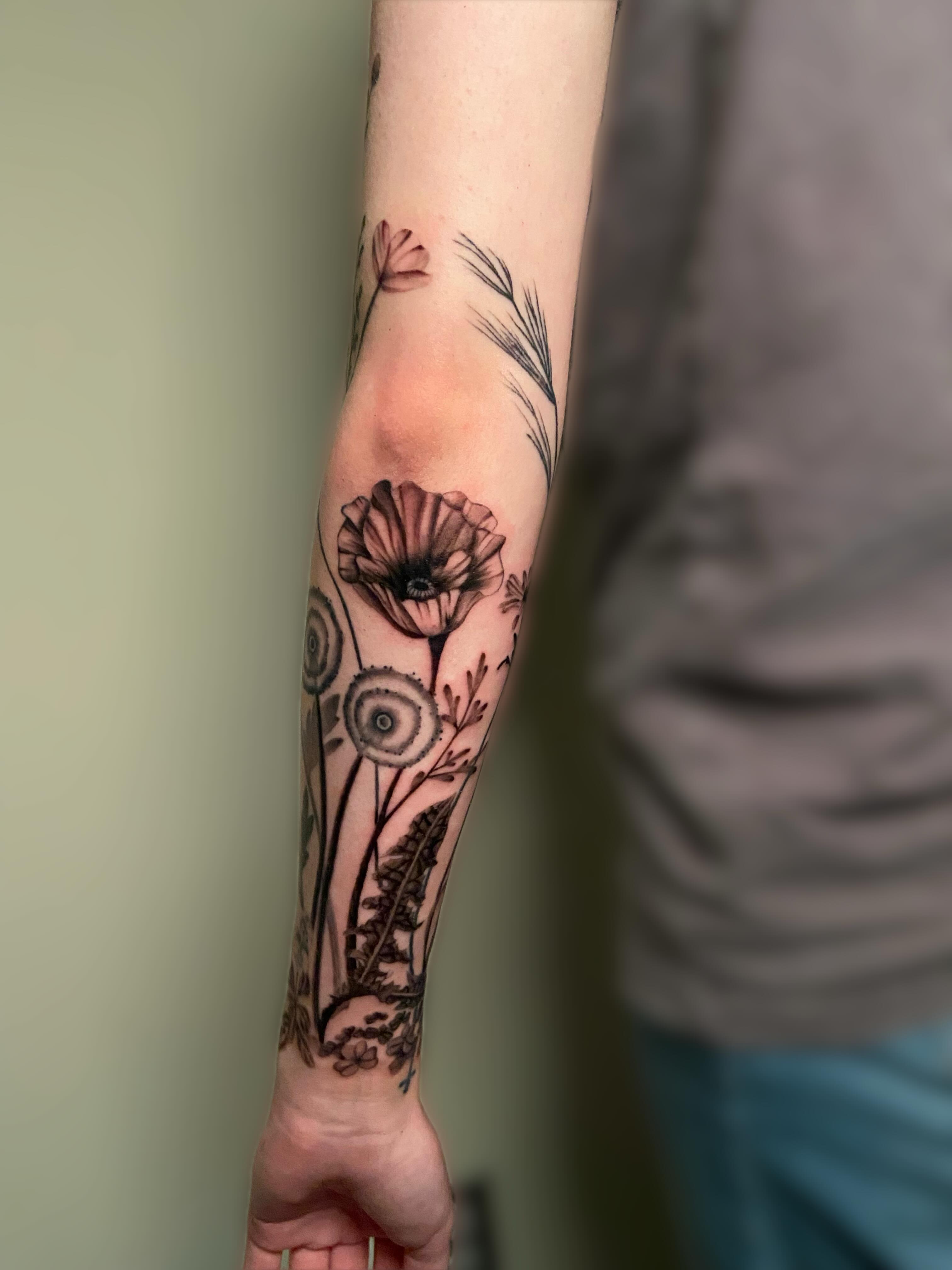 Floral arrangement black and grey tattoo on the forearm by Ezra Gonda