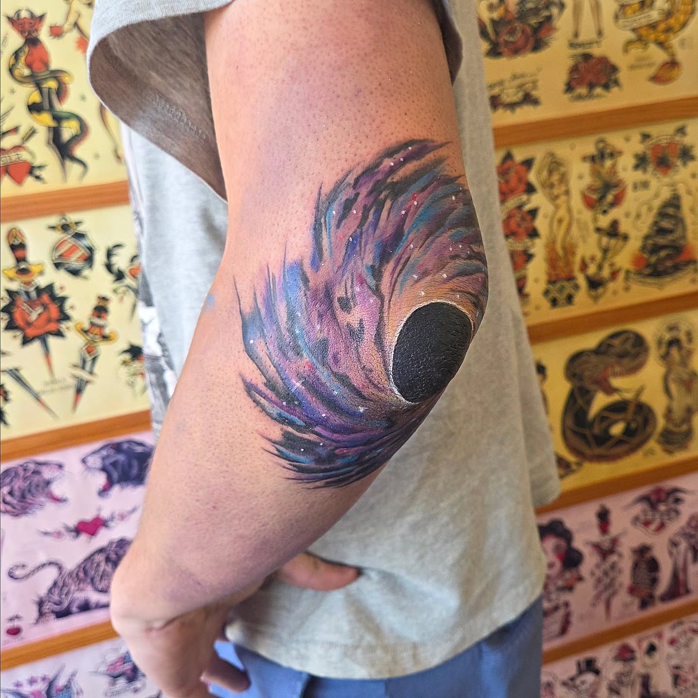 Peacock feather watercolor tattoo on the forearm by Kat Coniglio Art