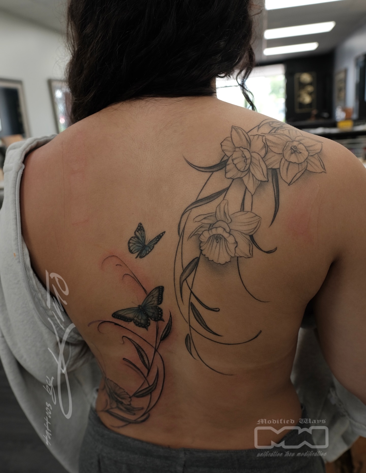 Daffodils and butterflies realism tattoo on the back by Kansas City tattoo artist