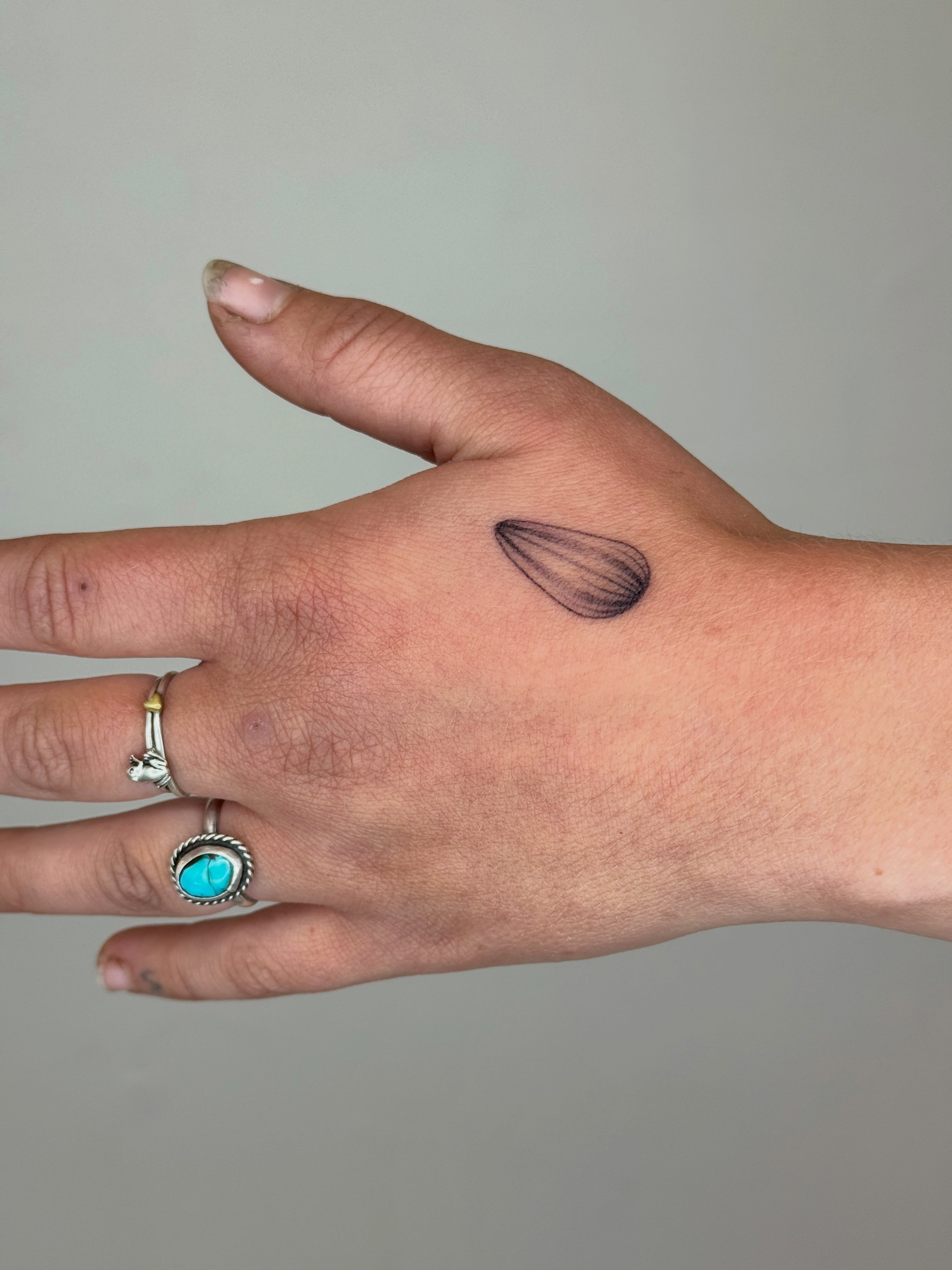 Eggplant black and grey tattoo on the hand by Monica Reynolds