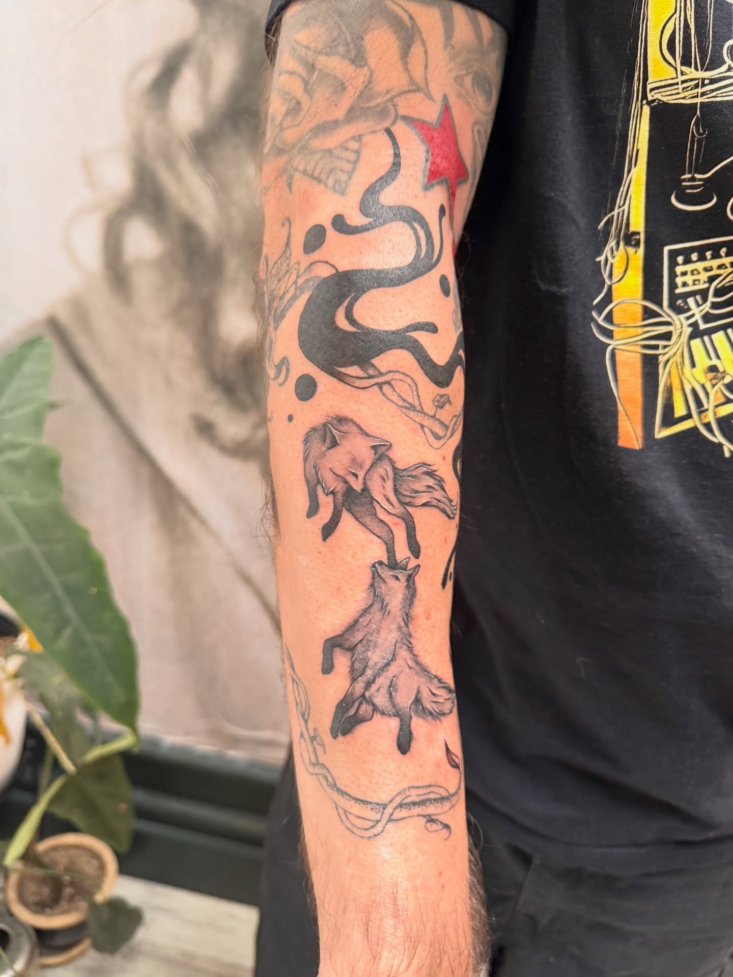 Foxes and star black and grey tattoo on the forearm by Sam Padilla