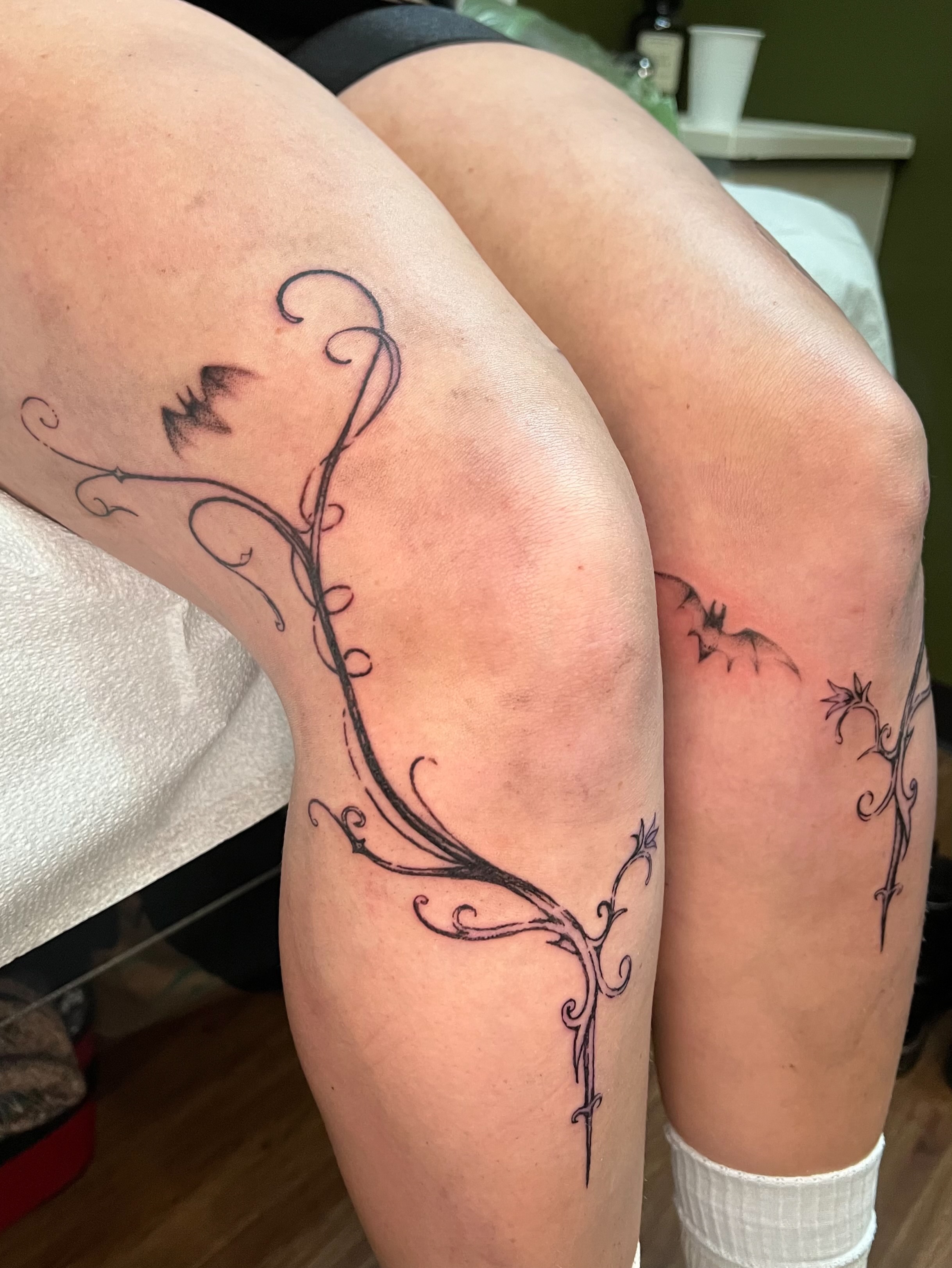 Vines and bats black and grey tattoo on the thigh by ꧁ 𝓛𝖎𝖛 ꧂, Cambridge, Massachusetts