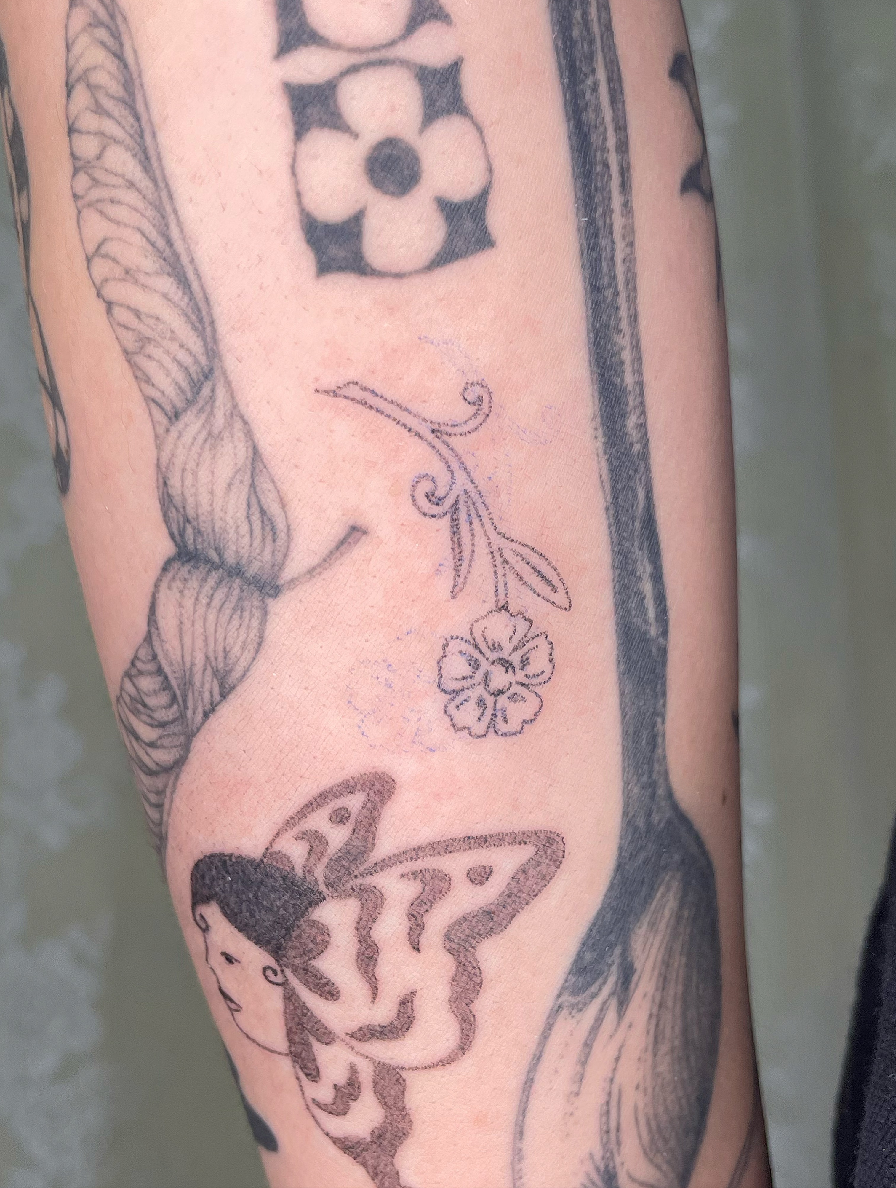 Butterfly and flower black and grey tattoo on the forearm by cait