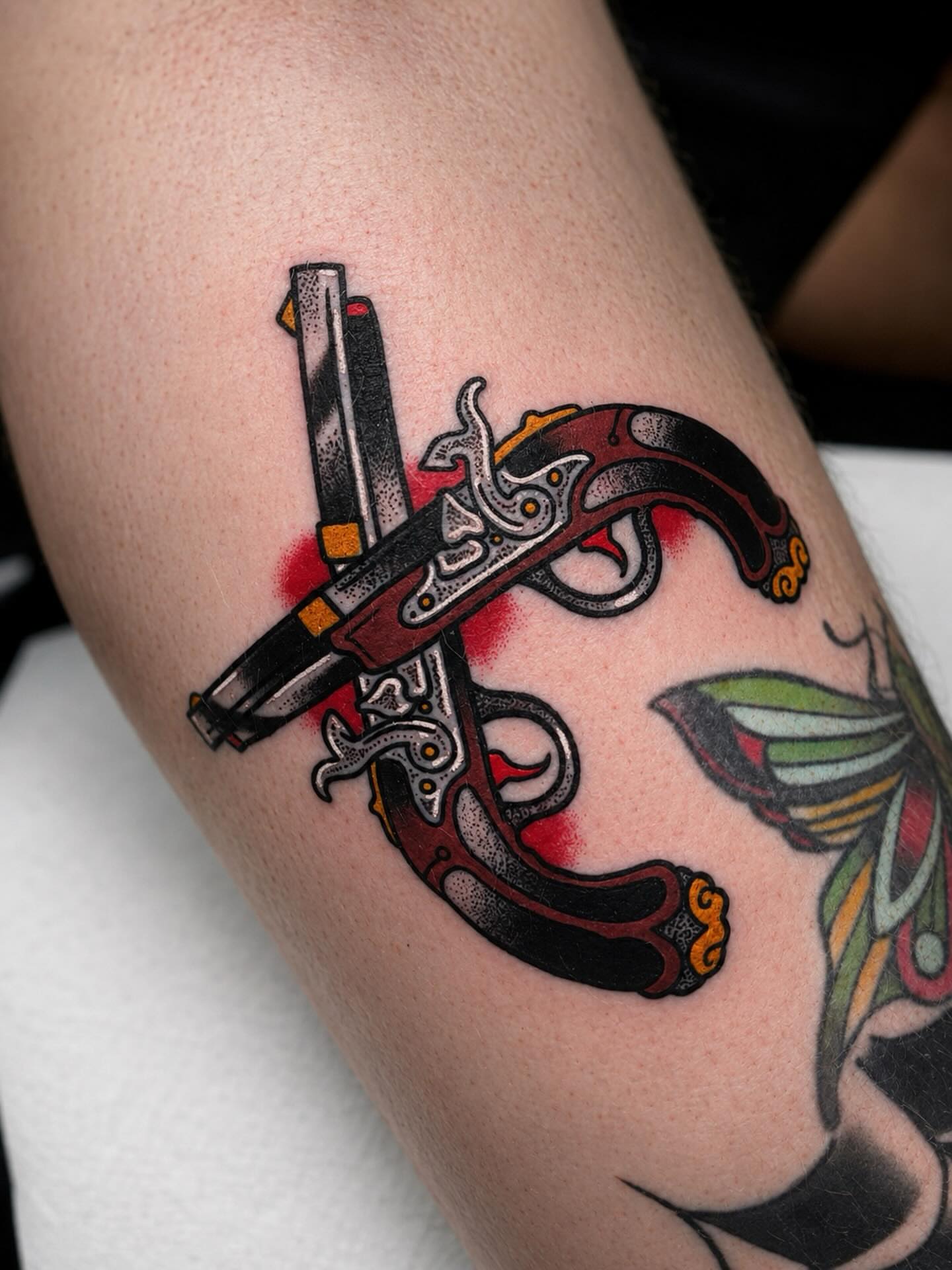 Gun and knife American traditional tattoo on the forearm by Todd Showdown