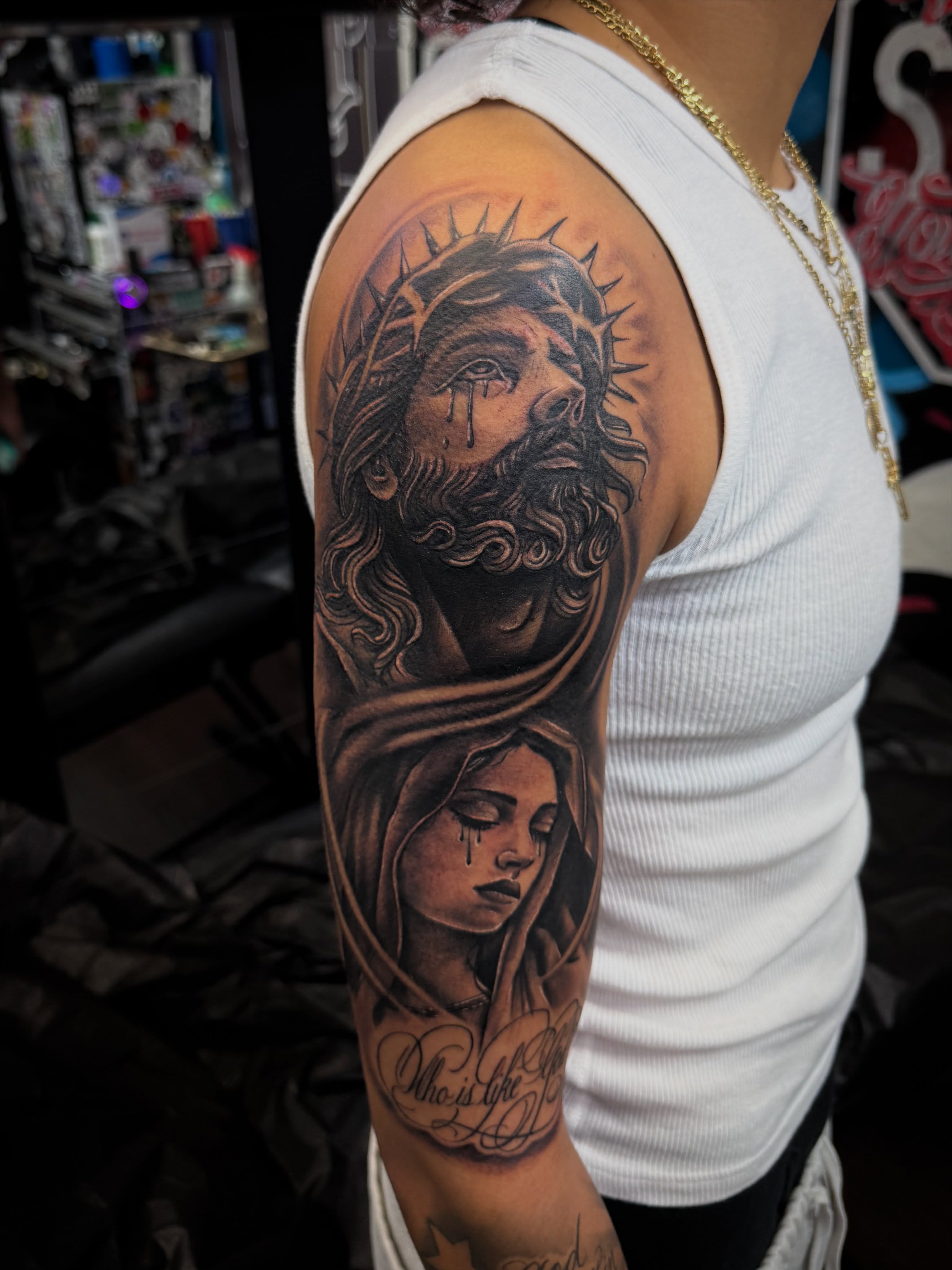 Religious figures realism tattoo on the upper arm by @samg_tat2s, San Diego, California