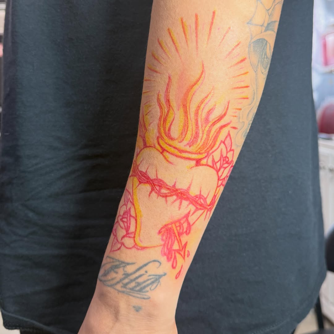 Flaming heart with crown of thorns neo-traditional tattoo on the forearm by H e I D I