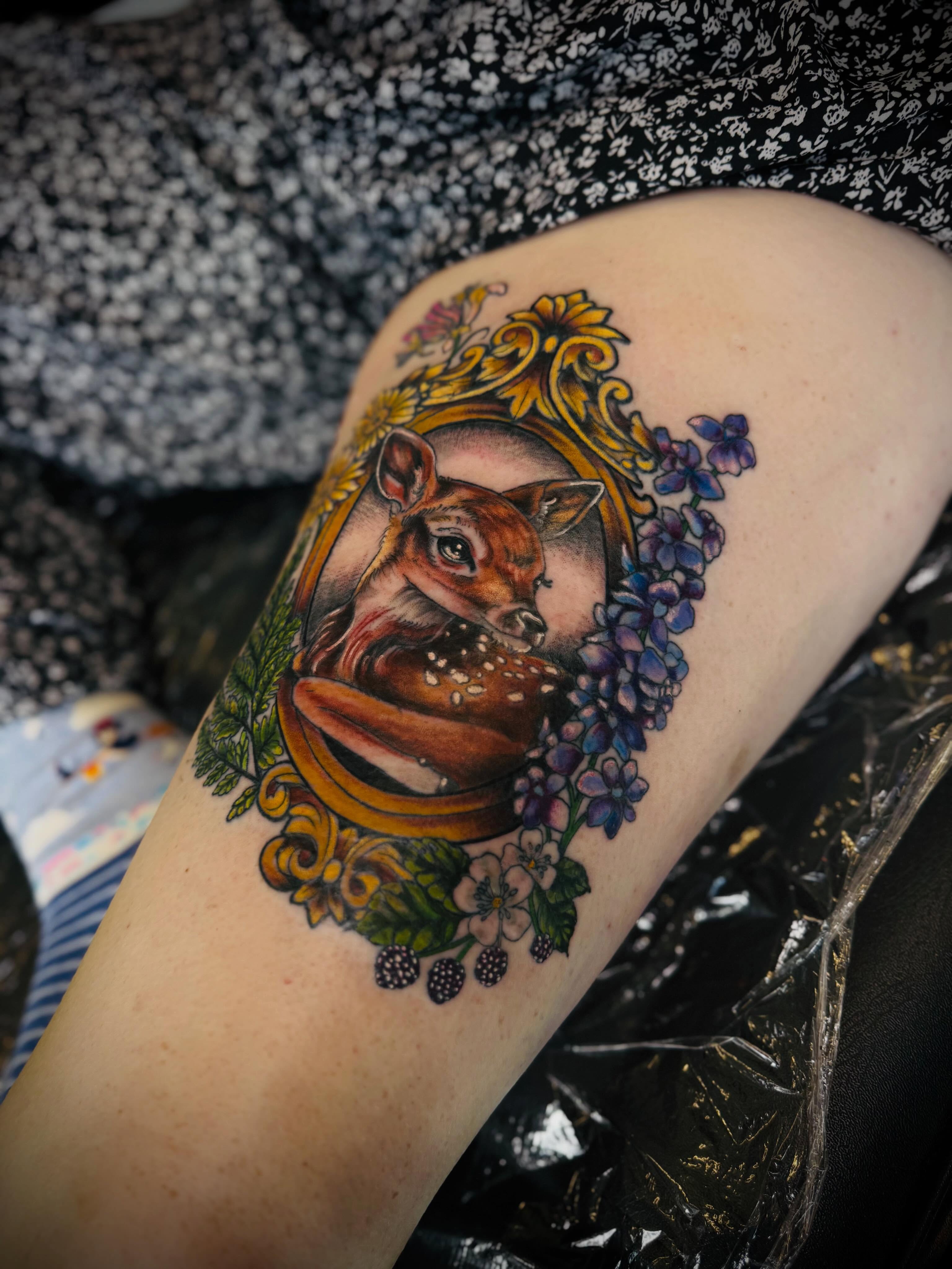 Deer and floral wreath realism tattoo on the thigh by Jessica Abbey
