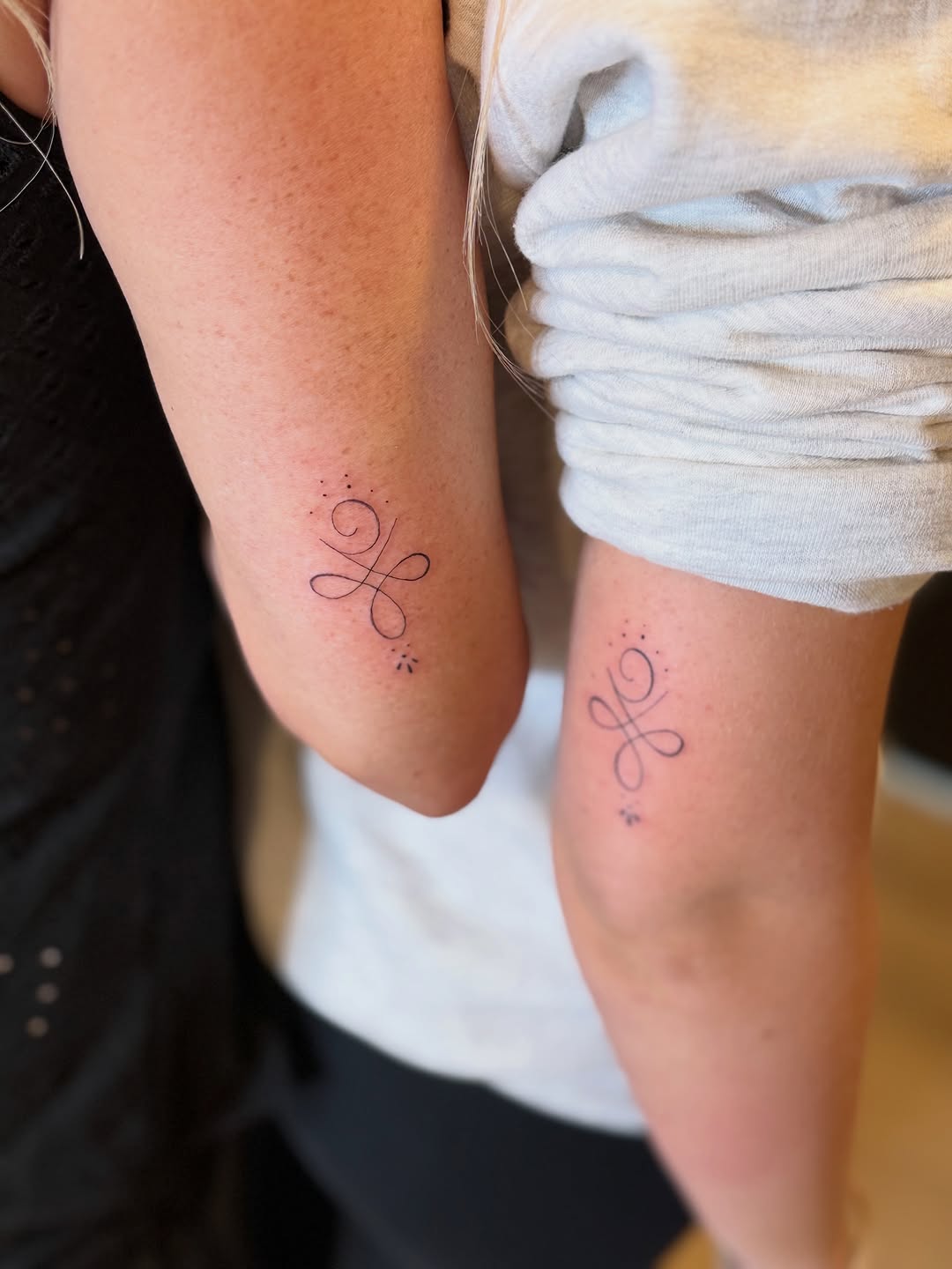 Symbol minimalist tattoo on the forearm by Fineline Tattoo