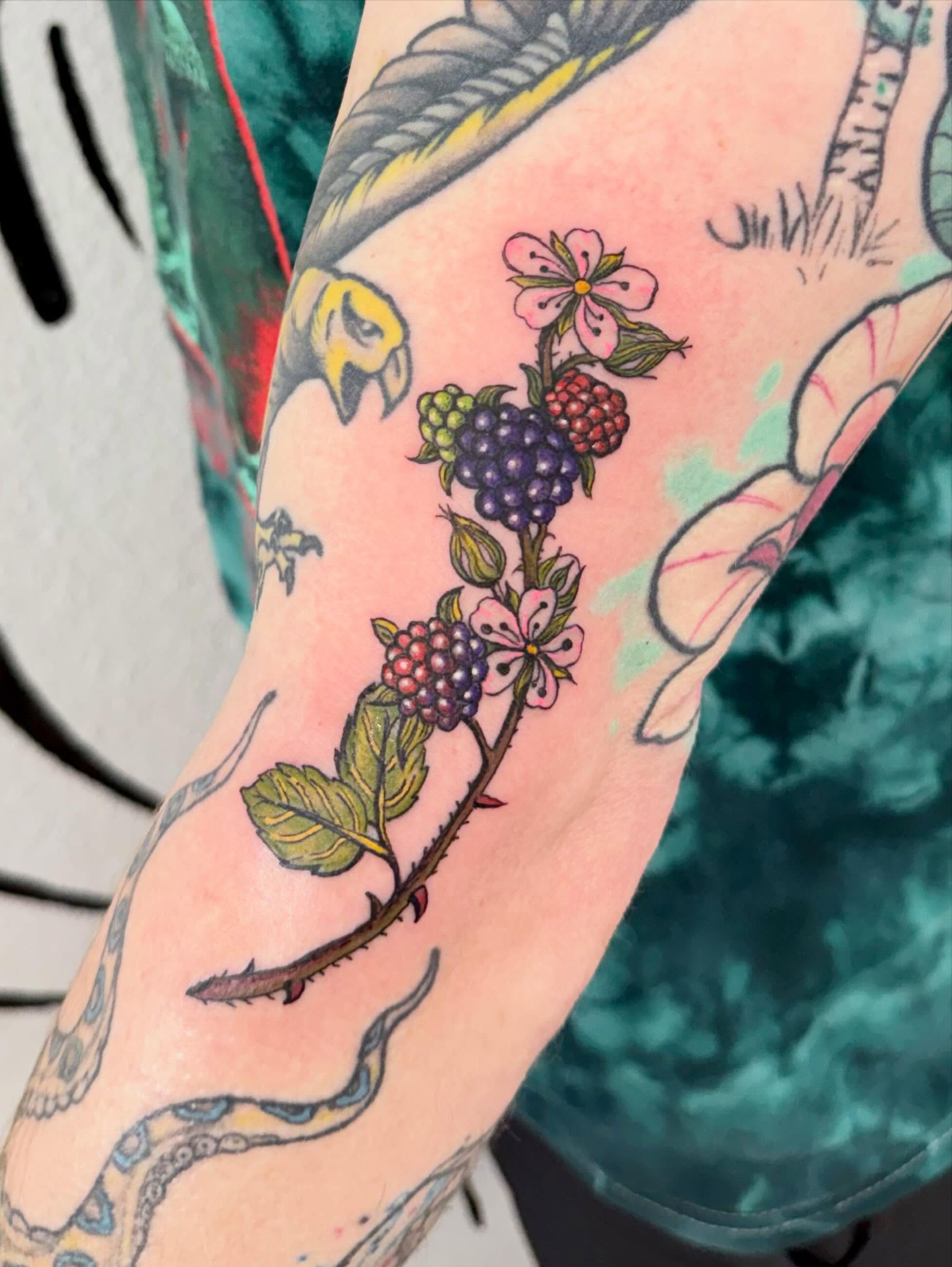 Berry branch with flowers new school tattoo on the forearm by Peggy