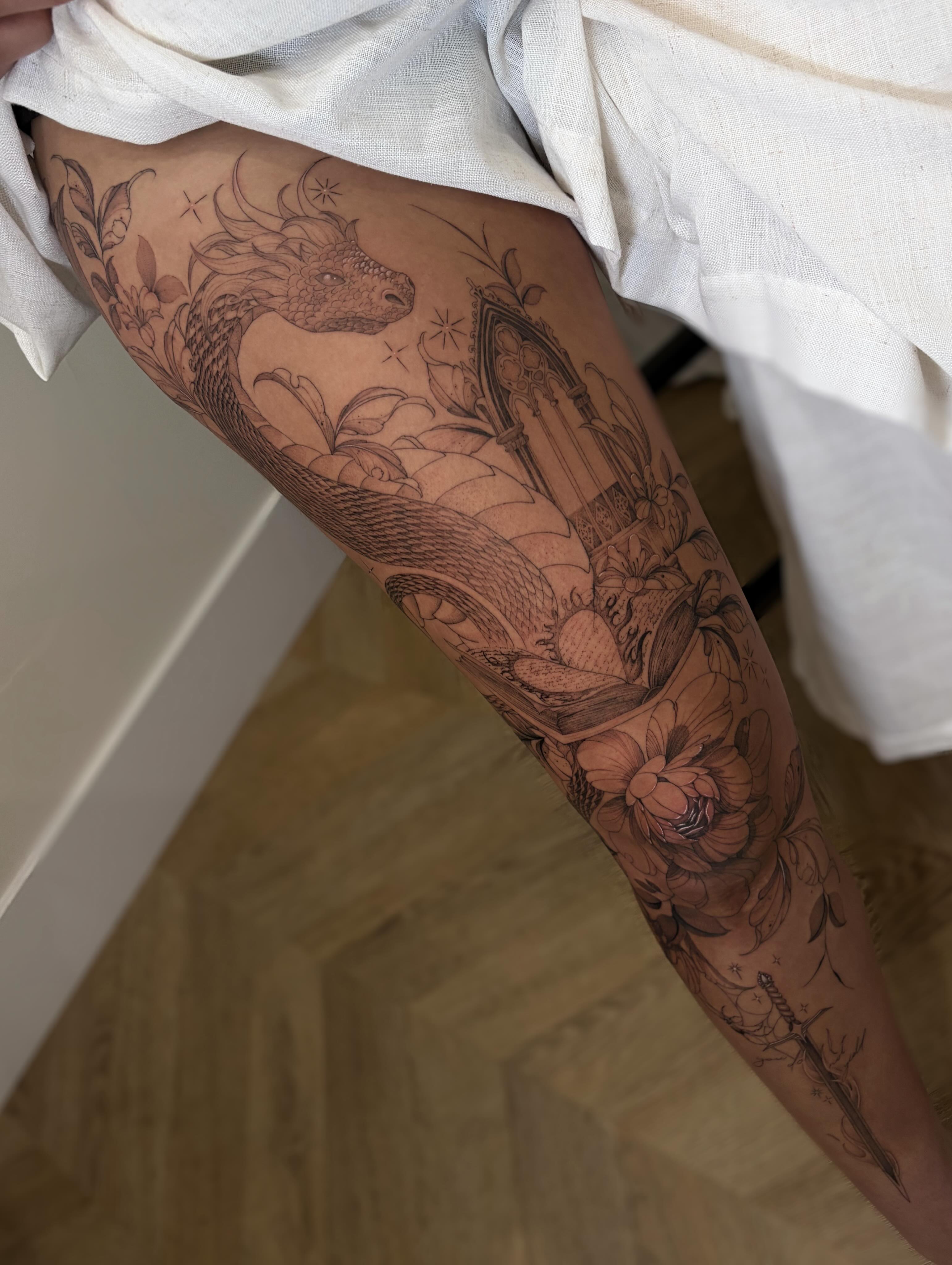 Mythical creature and floral realism tattoo on the thigh by Justene Renee 🖤 Fine Line Tattoo Artist