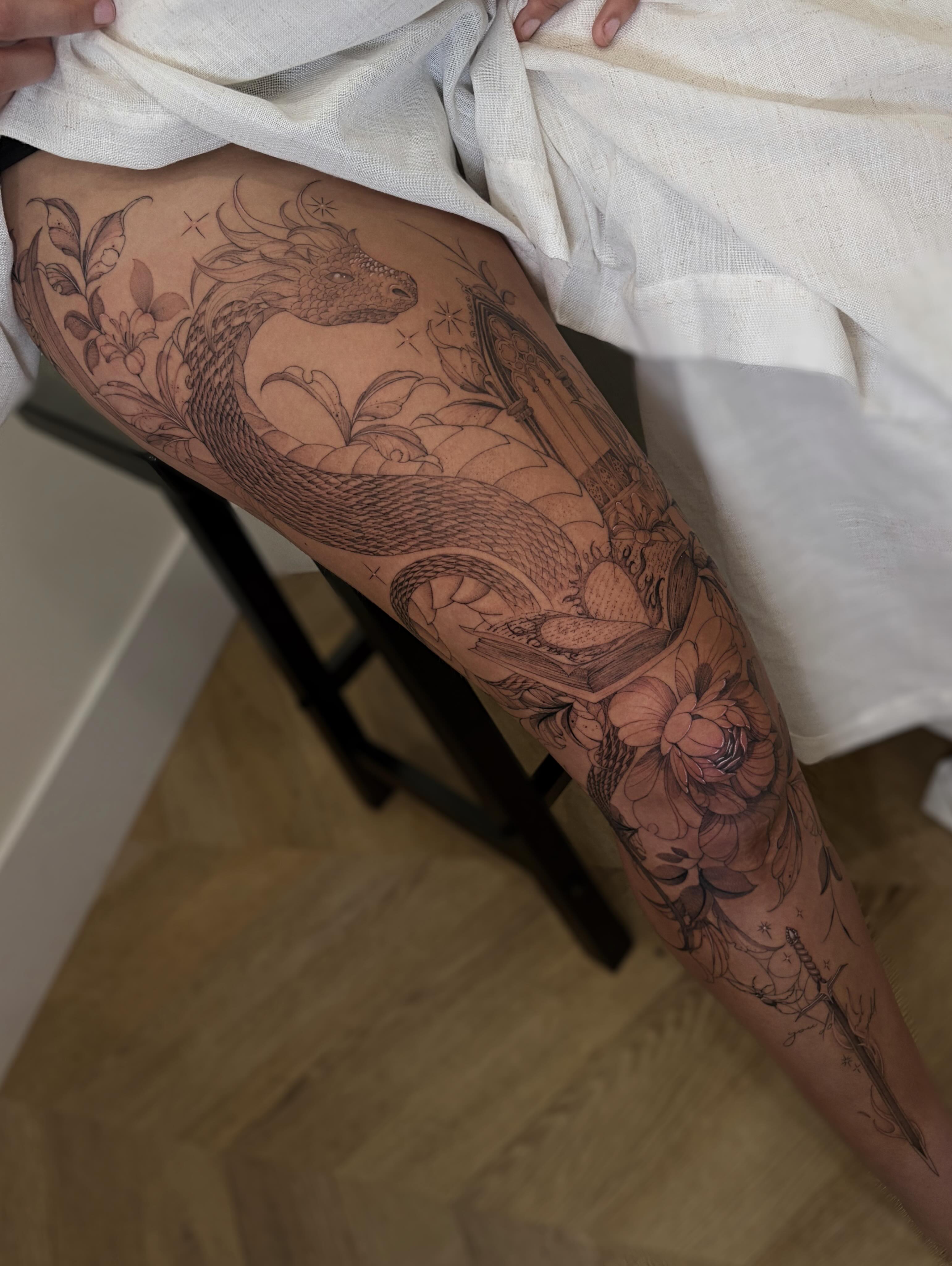 Dragon and floral black and grey tattoo on the thigh by Justene Renee 🖤 Fine Line Tattoo Artist