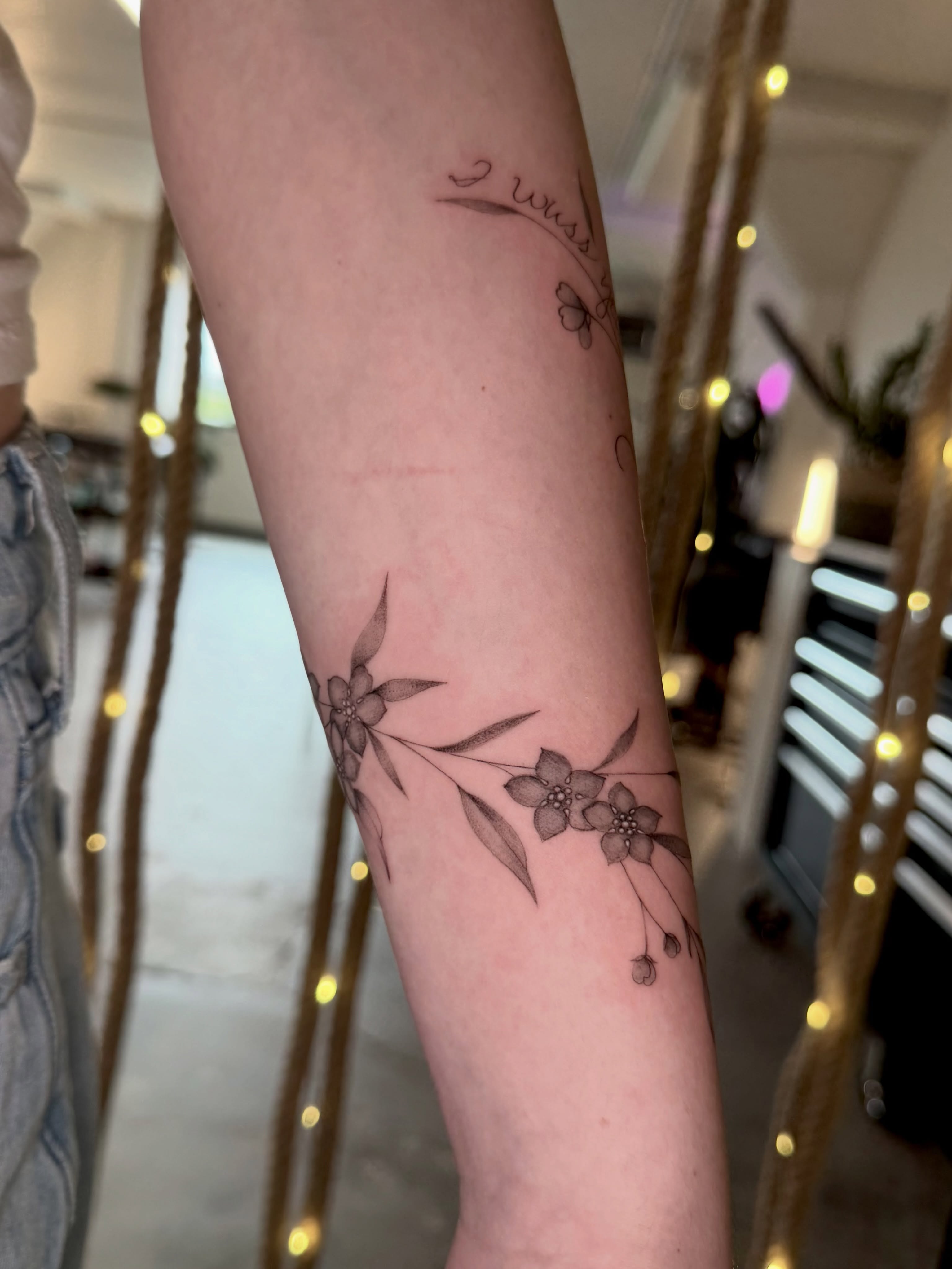 Cherry blossoms fine line tattoo on the forearm by Anna