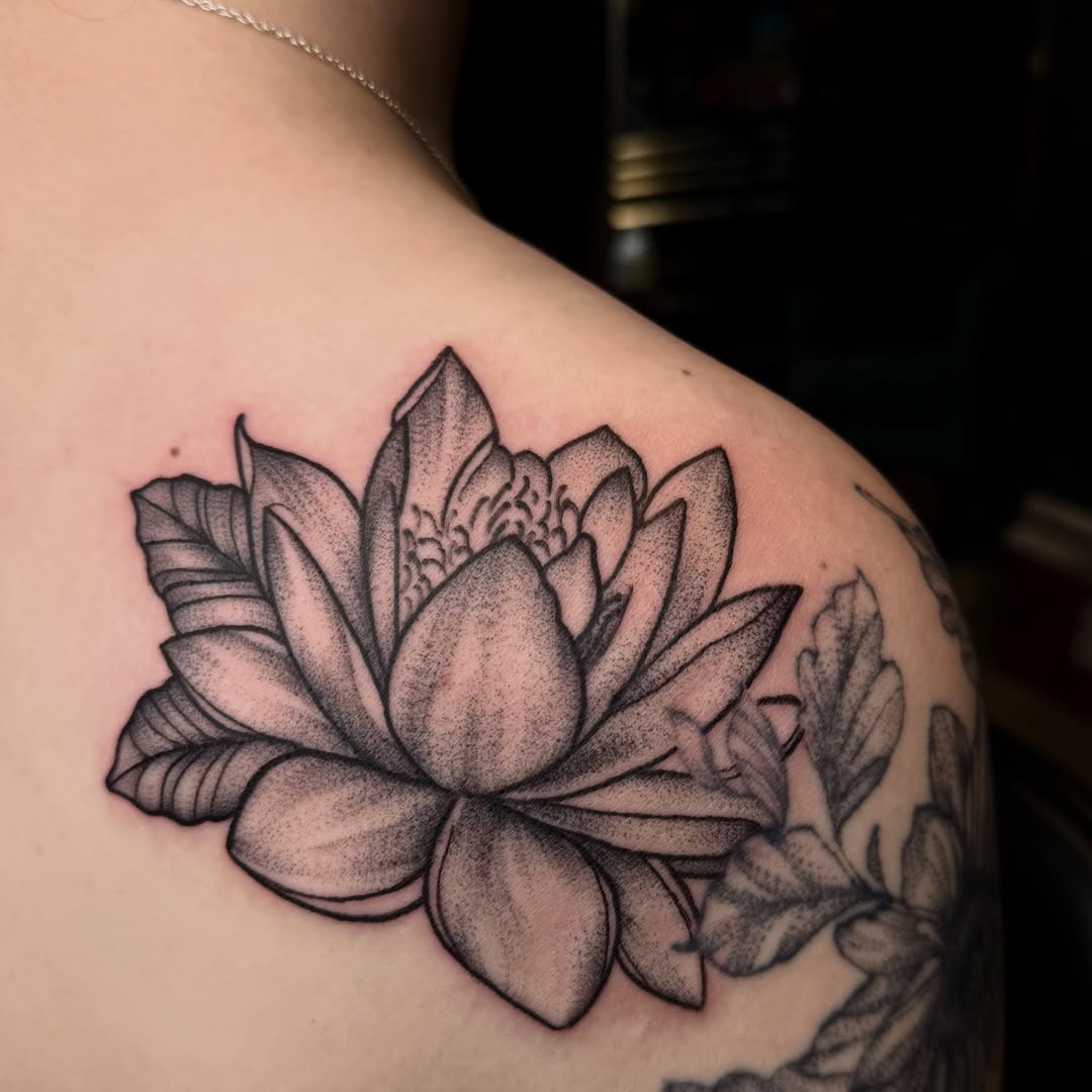 Lotus flower dotwork tattoo on the shoulder by Jennifer Contreras