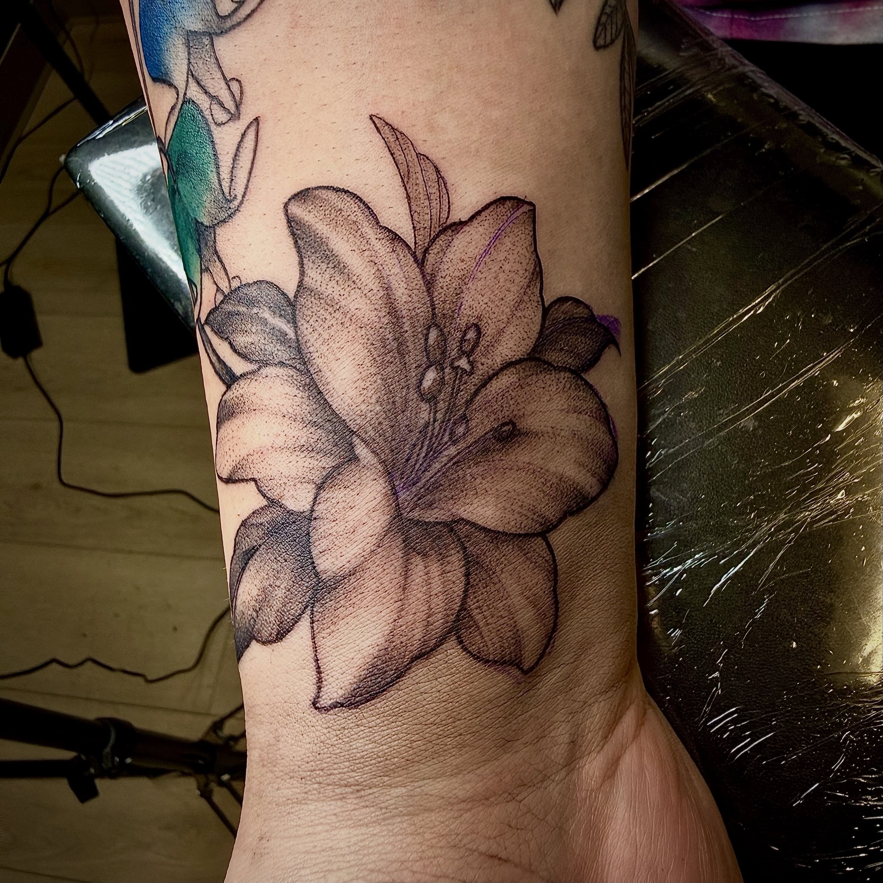 Lily dotwork tattoo on the forearm by Jennifer Contreras