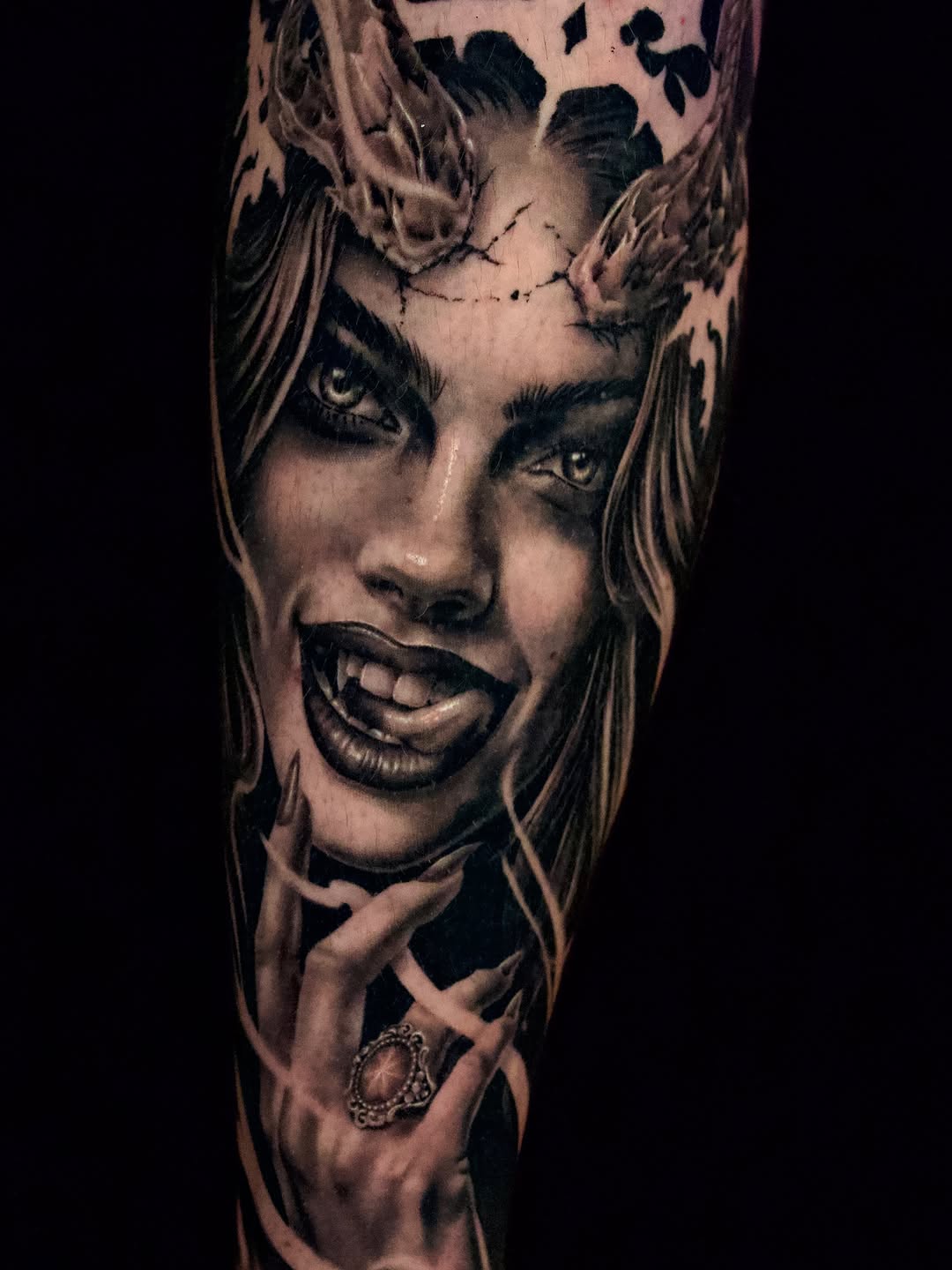 Woman with horns and fangs realism tattoo on the forearm by April Lynn