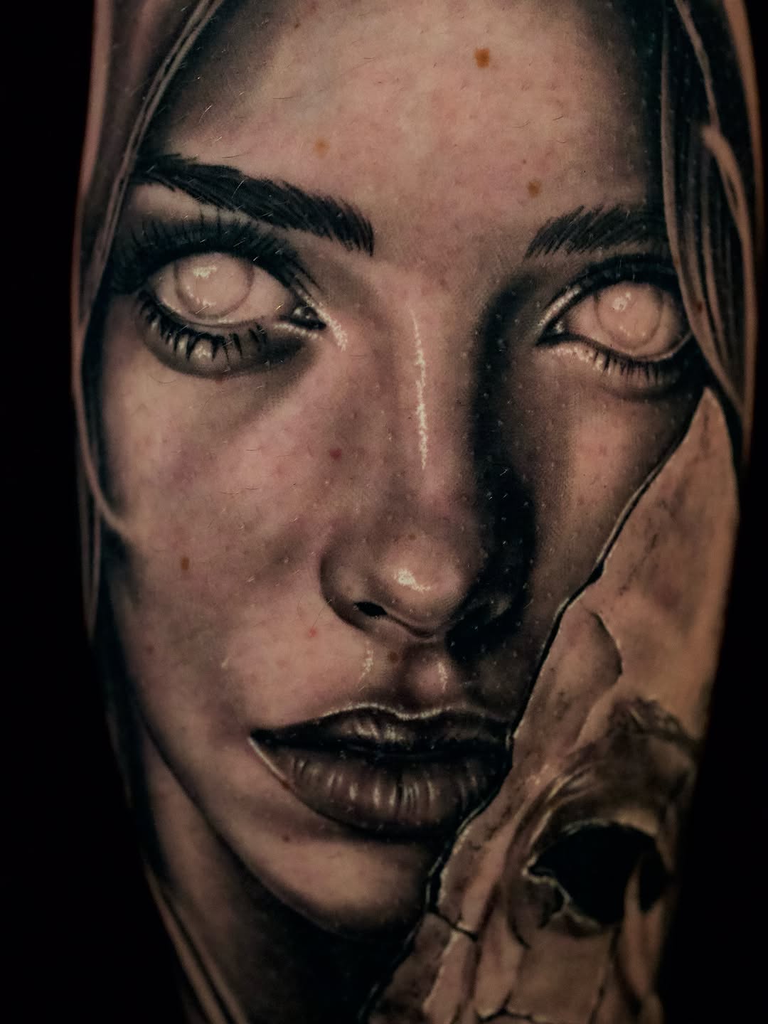 Woman's face and skull fragment realism tattoo on the forearm by April Lynn