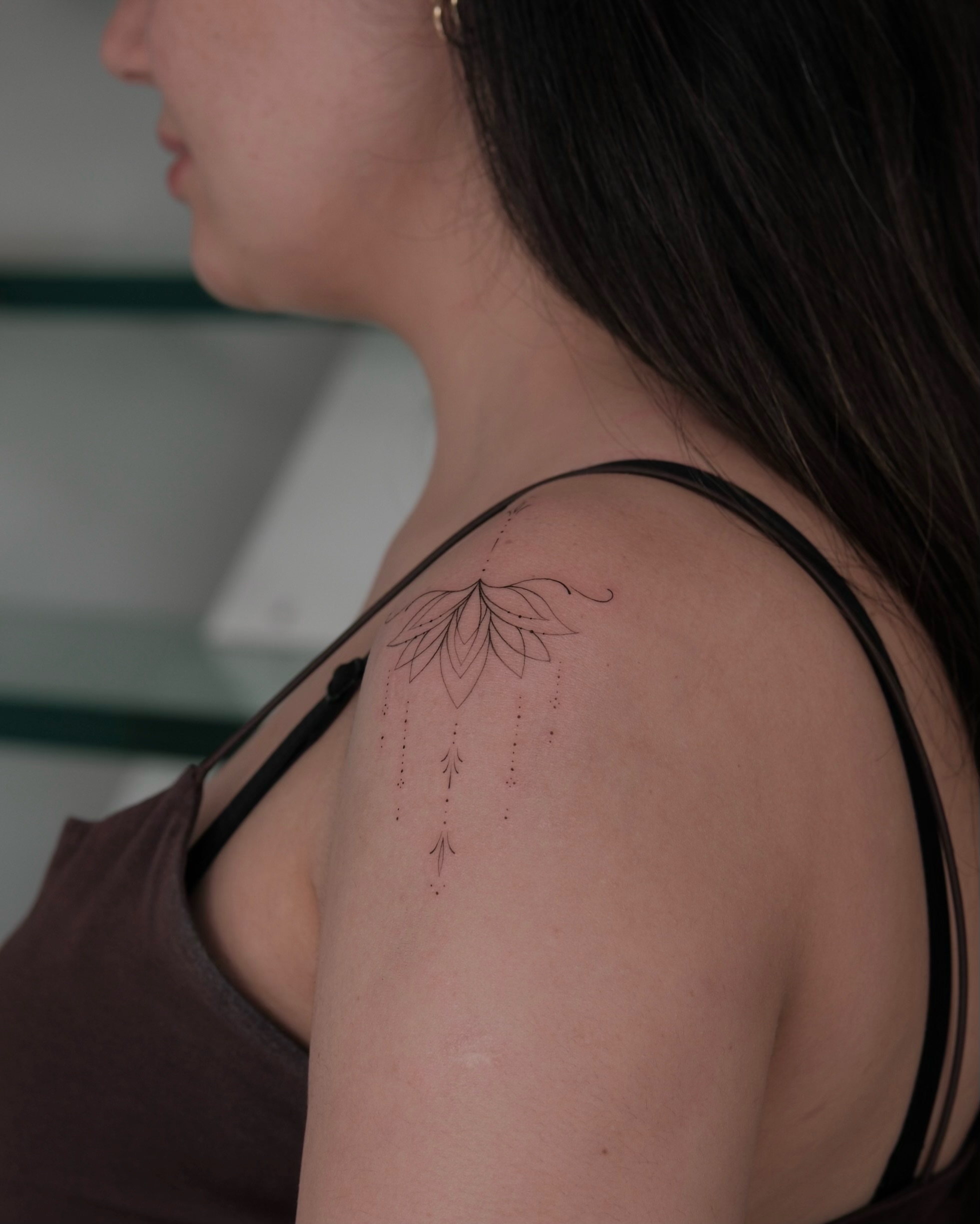 Lotus fine line tattoo on the shoulder by Göksu