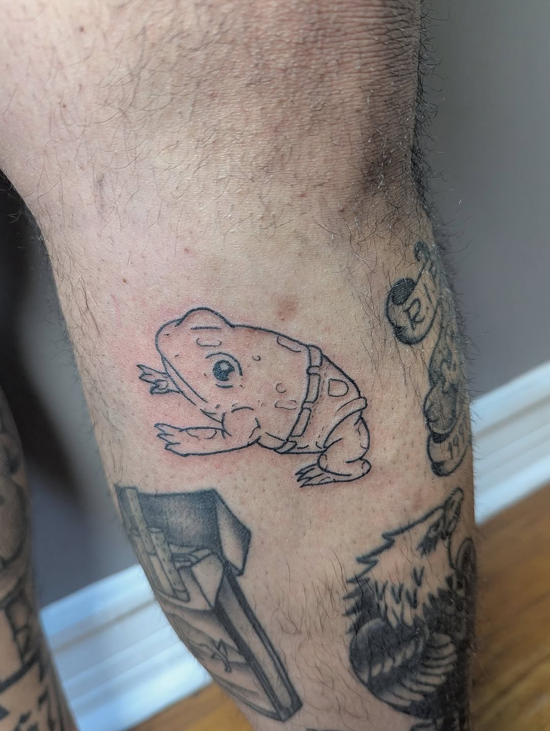 Frog wearing a harness American traditional tattoo on the forearm by Patricio