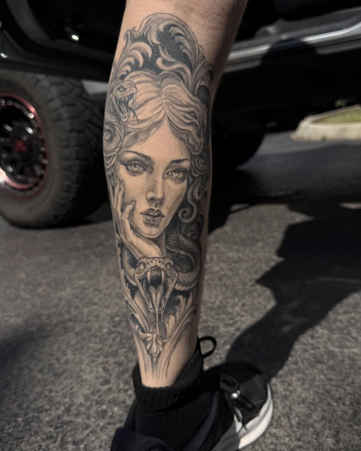 Woman with snake realism tattoo on the forearm by Danny Stewart
