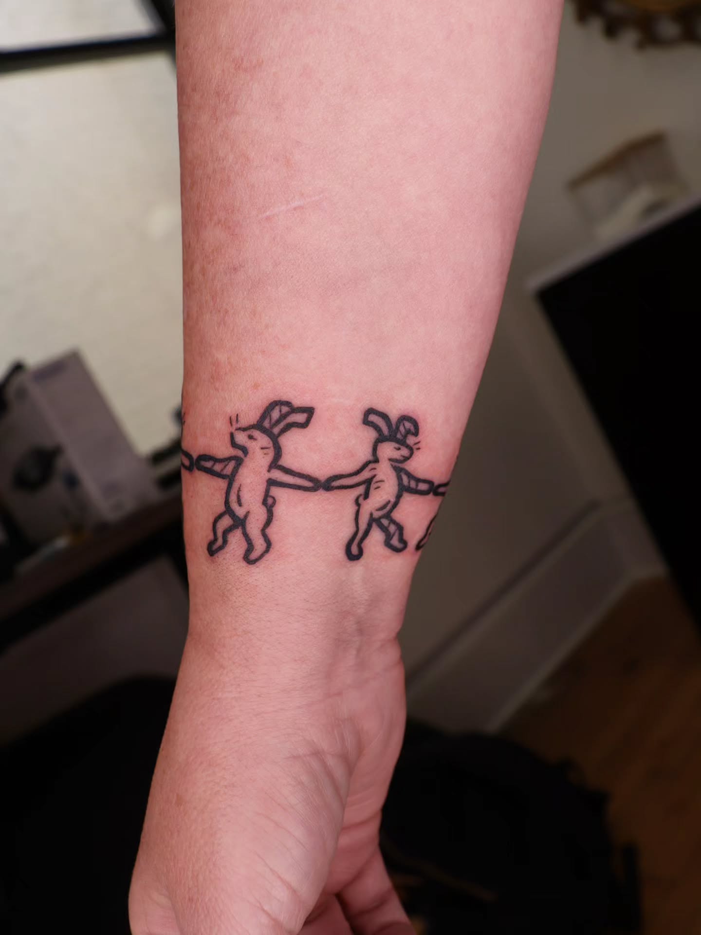 Bunnies black and grey tattoo on the forearm by Veronika Lipchak
