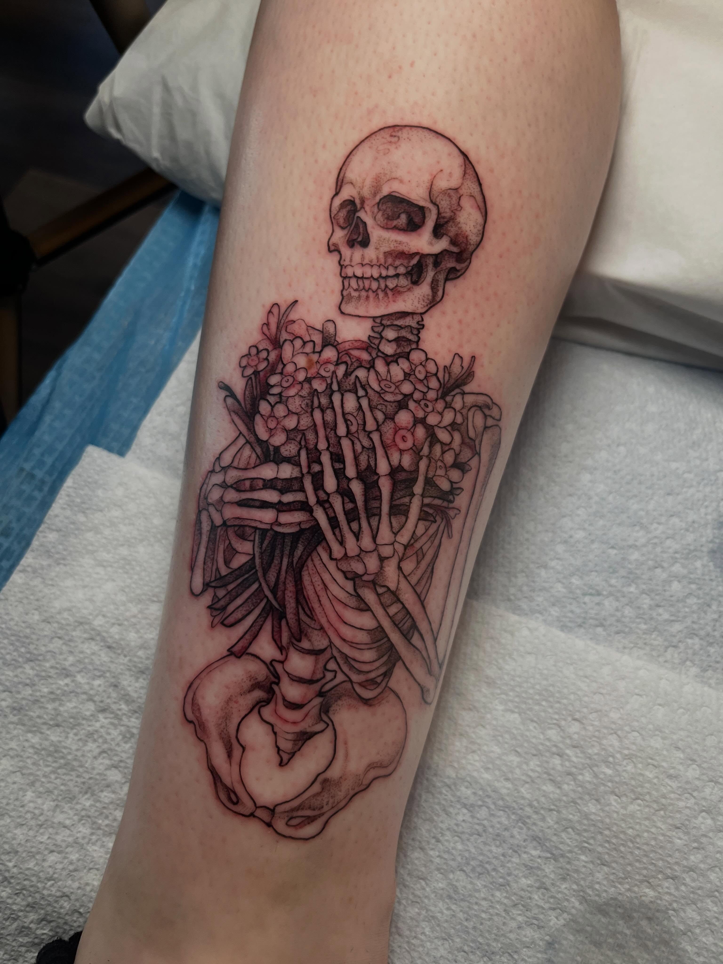Skeleton with flowers realism tattoo on the forearm by Cassandra
