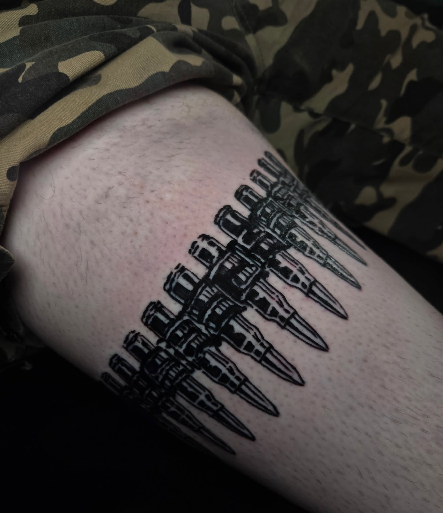 Bullet casings black and grey tattoo on the forearm by Lane