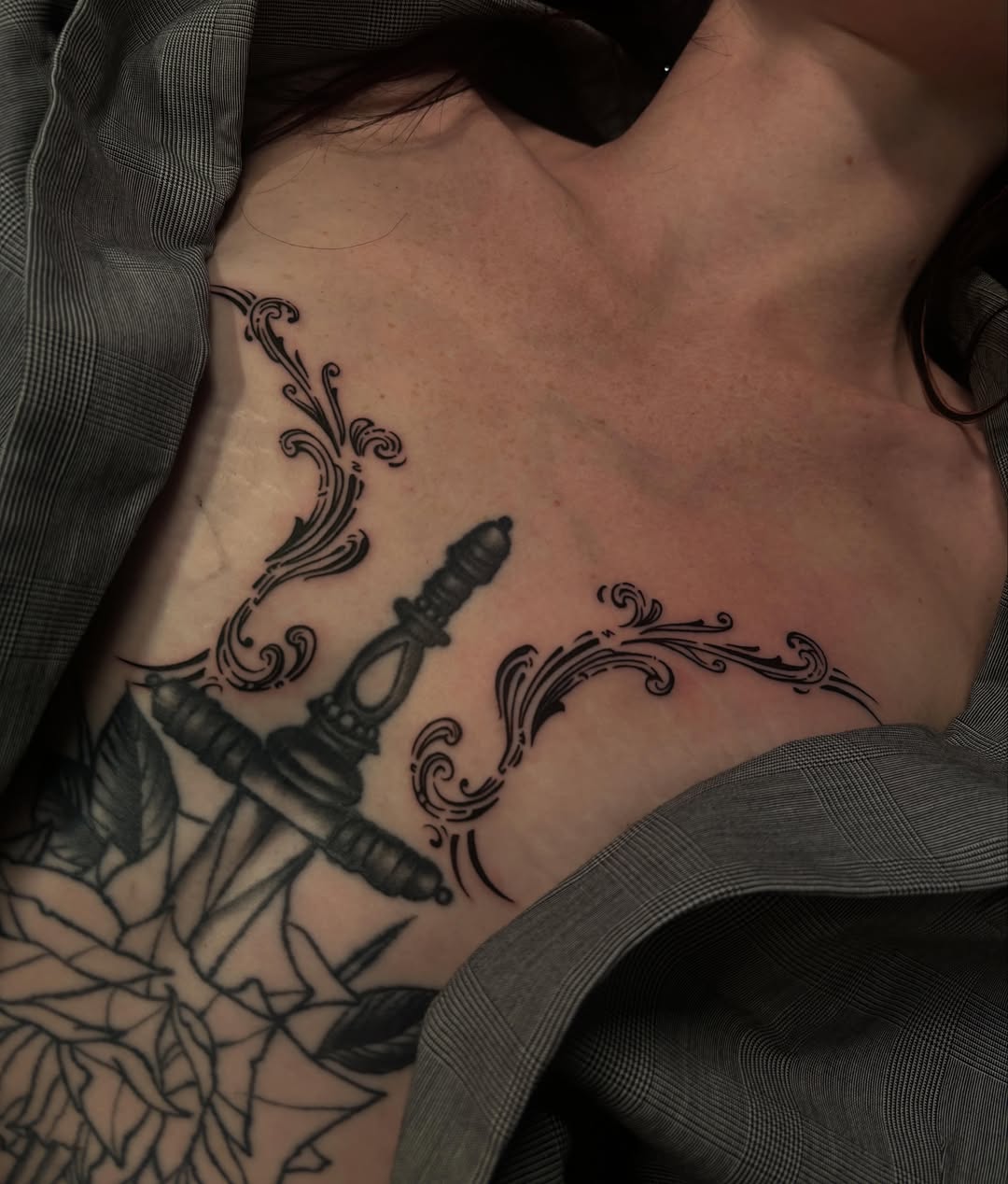 Sword and floral ornament black and grey tattoo on the chest by 𝕶𝖆𝖒 ~ 𝕿𝖆𝖙𝖙𝖔𝖔 𝕬𝖗𝖙𝖎𝖘𝖙