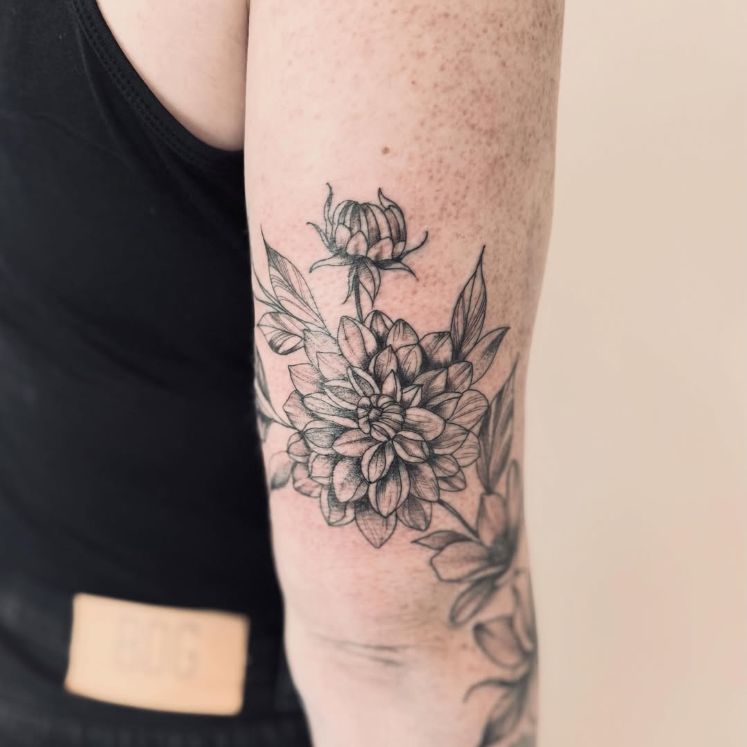 Dahlia flower black and grey tattoo on the forearm by Jessica Abbey