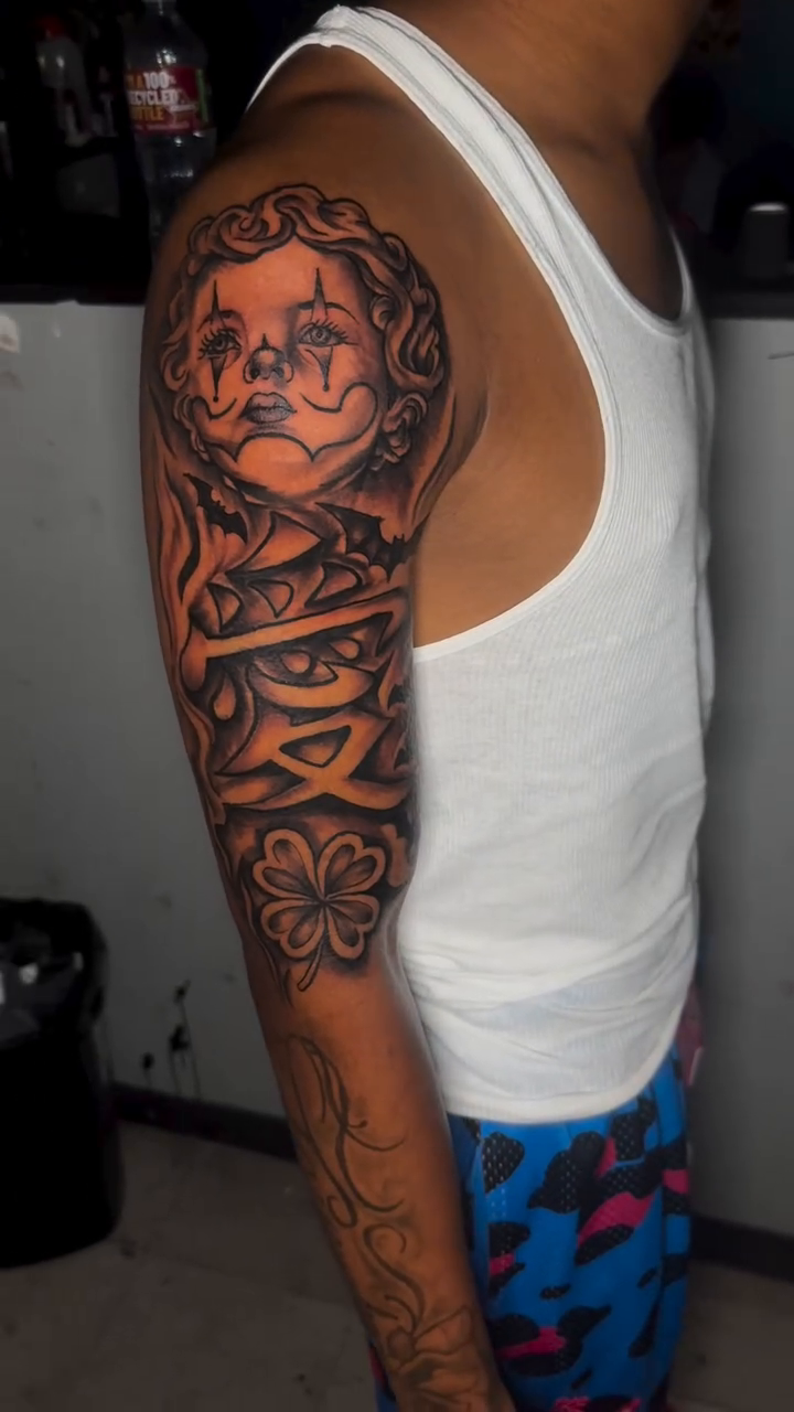 Sad clown face with tribal patterns Chicano tattoo by Dope