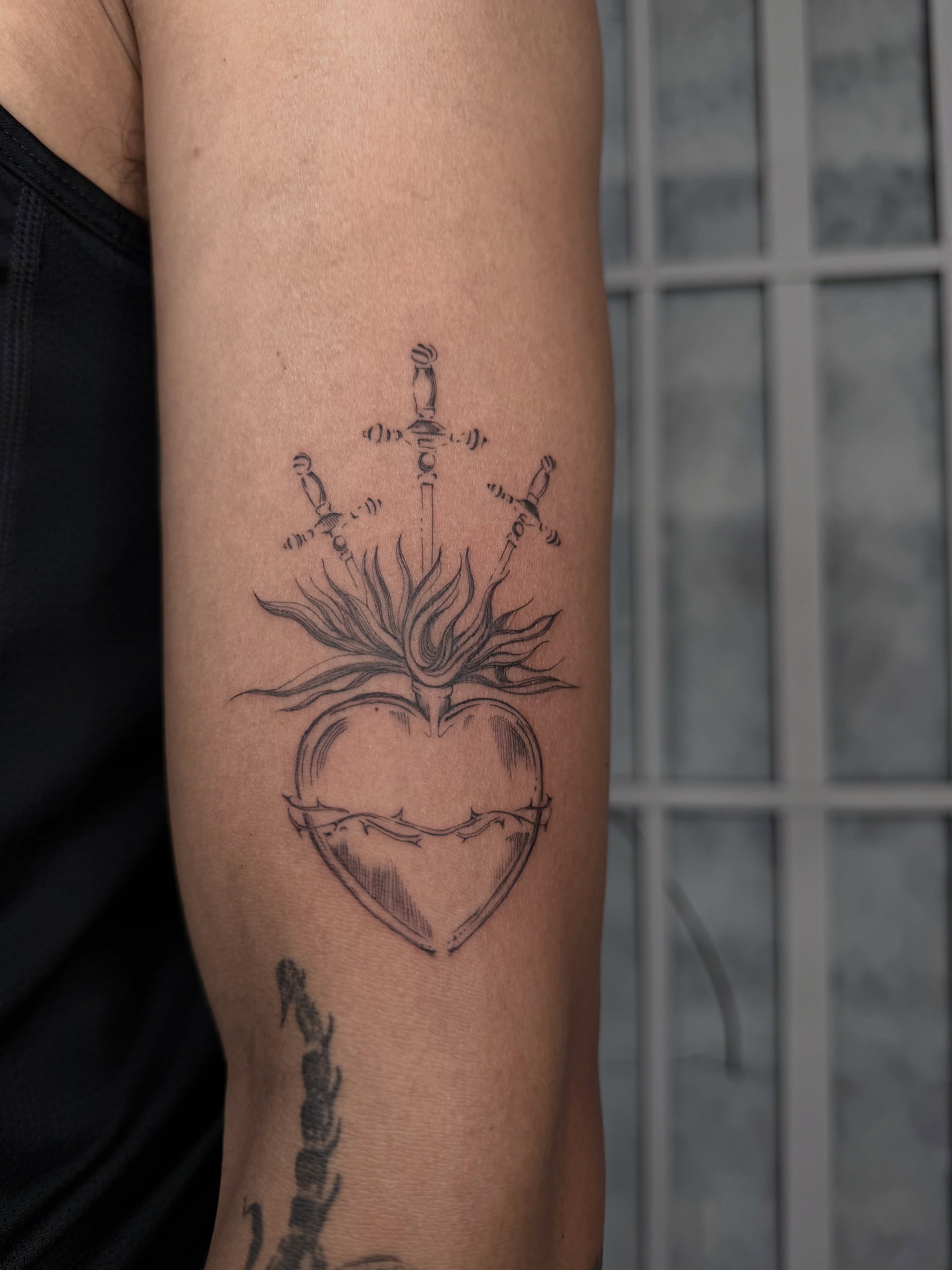 Sacred heart with swords black and grey tattoo on the forearm by jewel renee