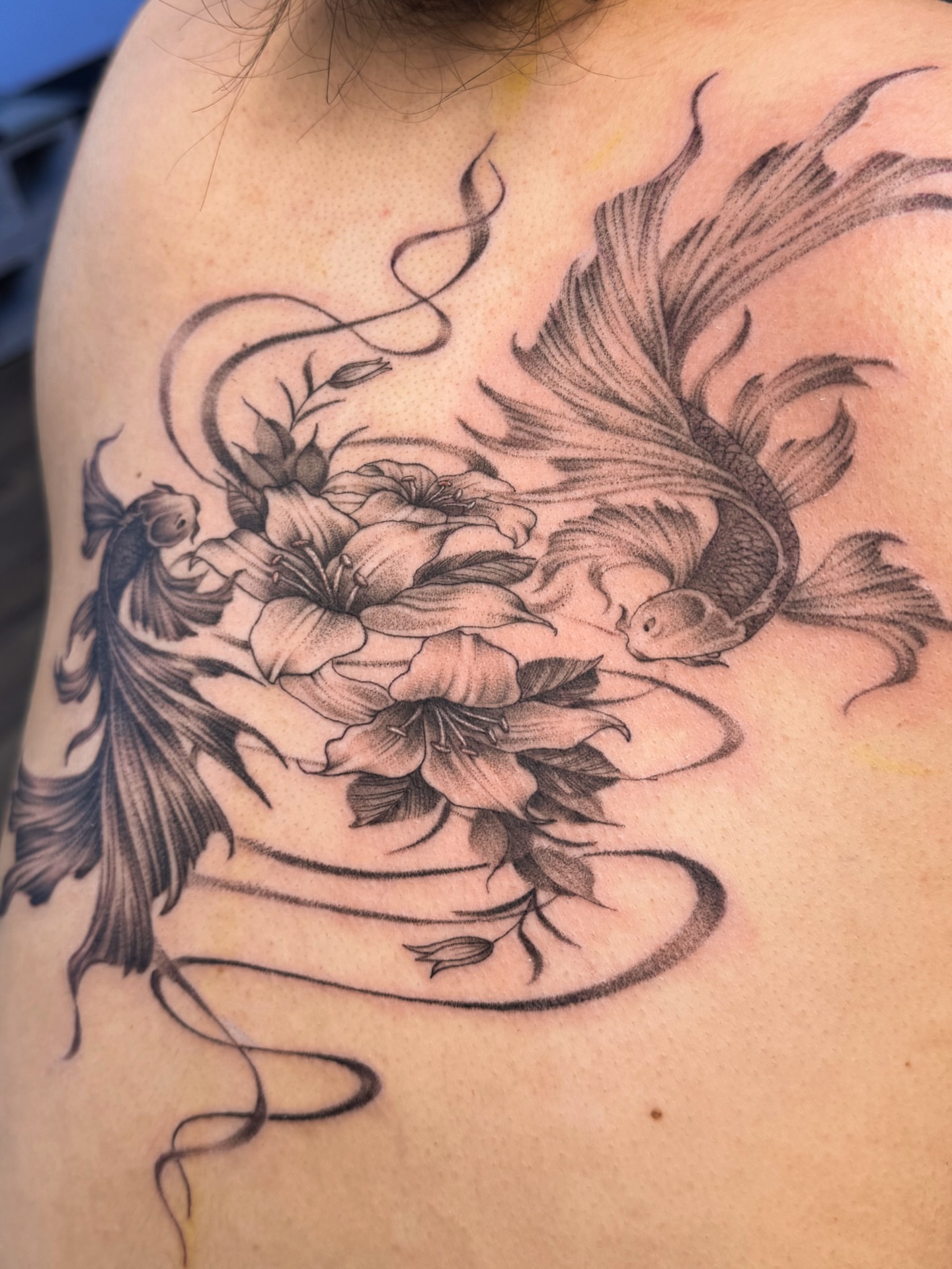 Koi fish and lotus realism tattoo on the shoulder by @nudylicioustattoos