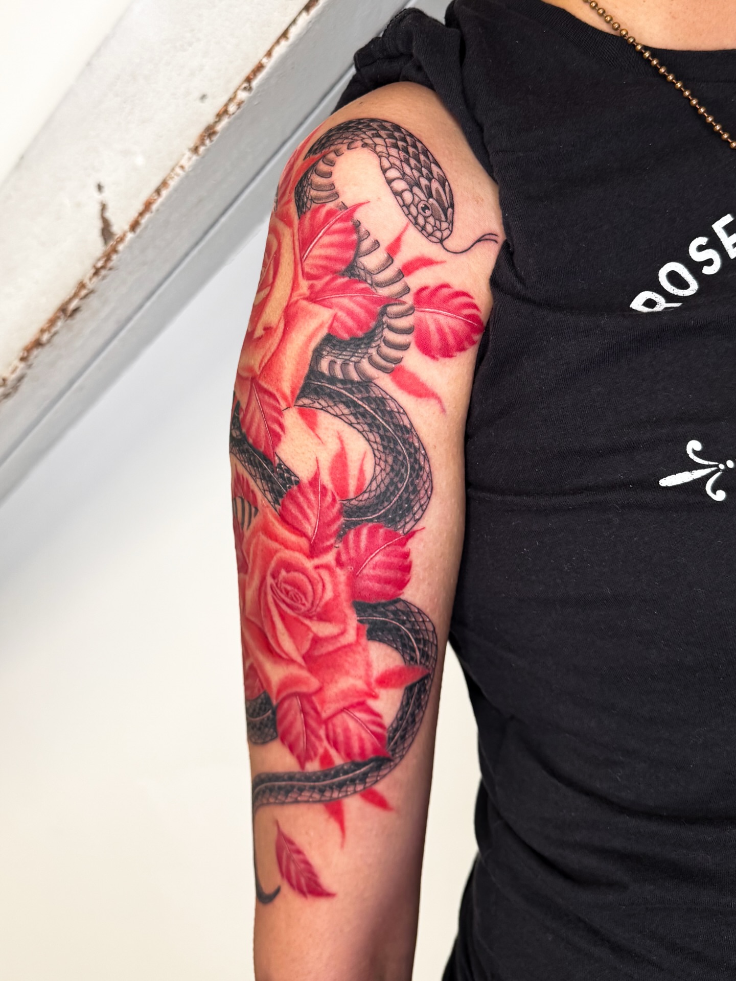 Snake and roses realism tattoo on the forearm by @nudylicioustattoos