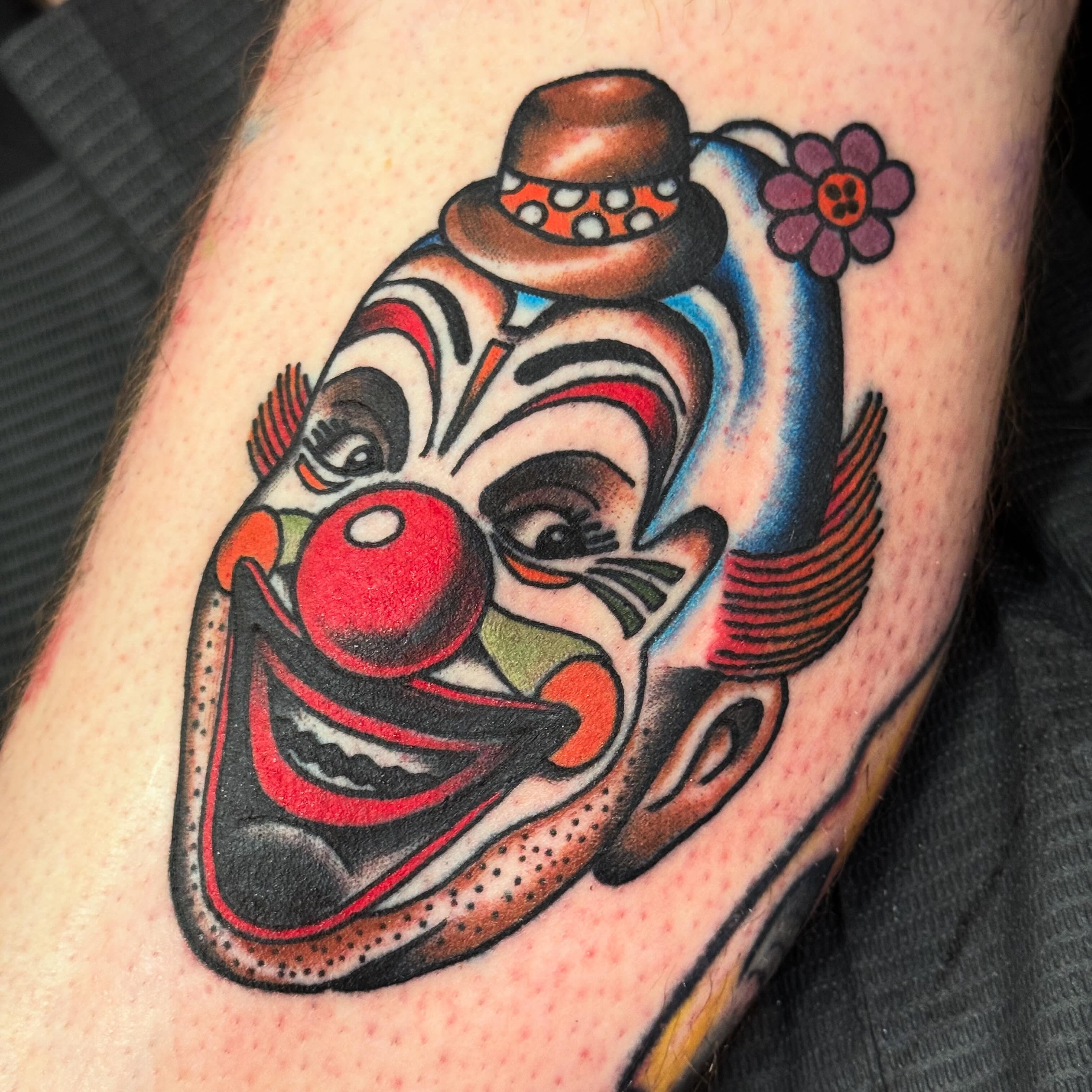 Clown face American traditional tattoo on the forearm by Jack Hatchet Tattoos
