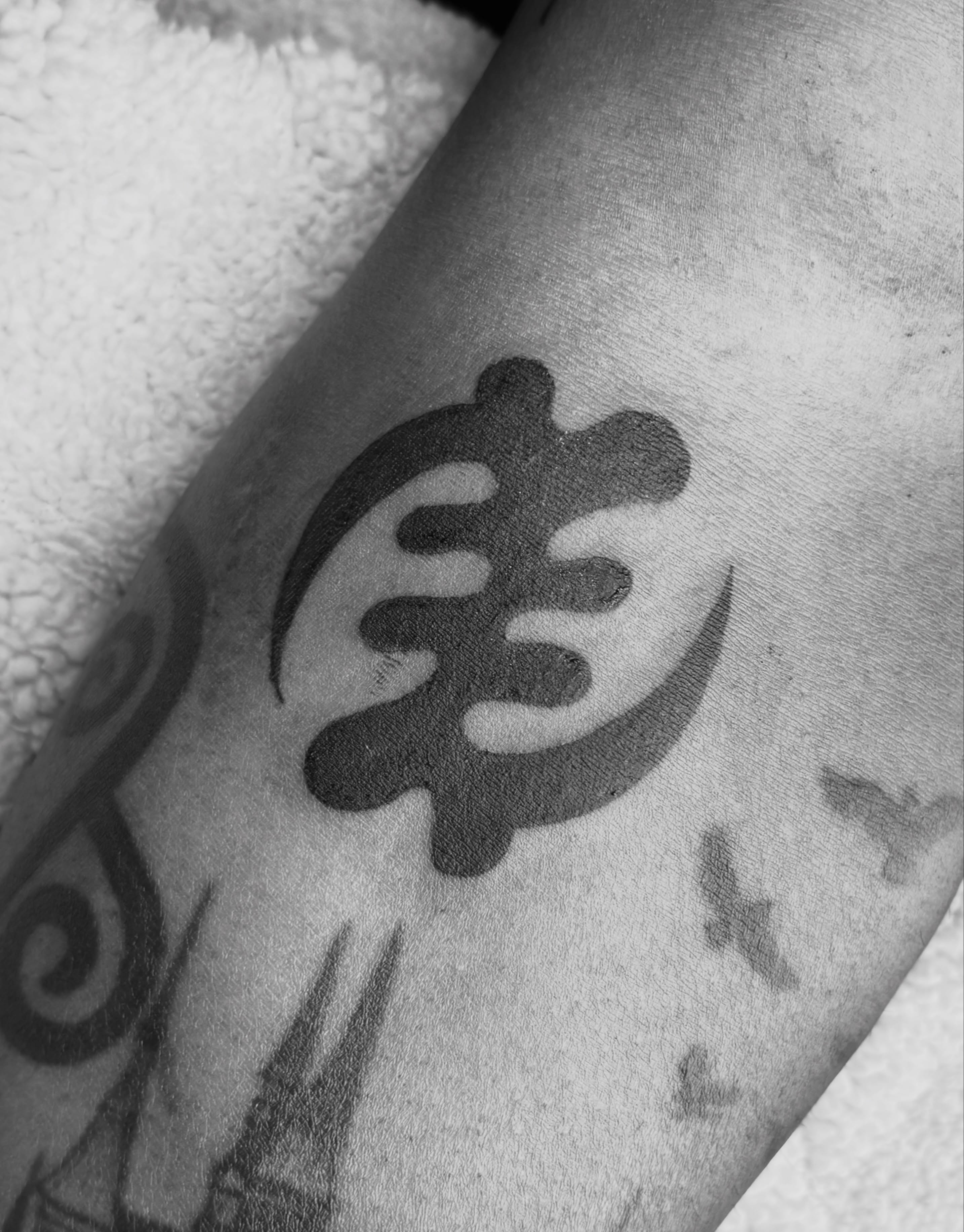 Abstract symbol black and grey tattoo on the forearm by @secretlinetattoo