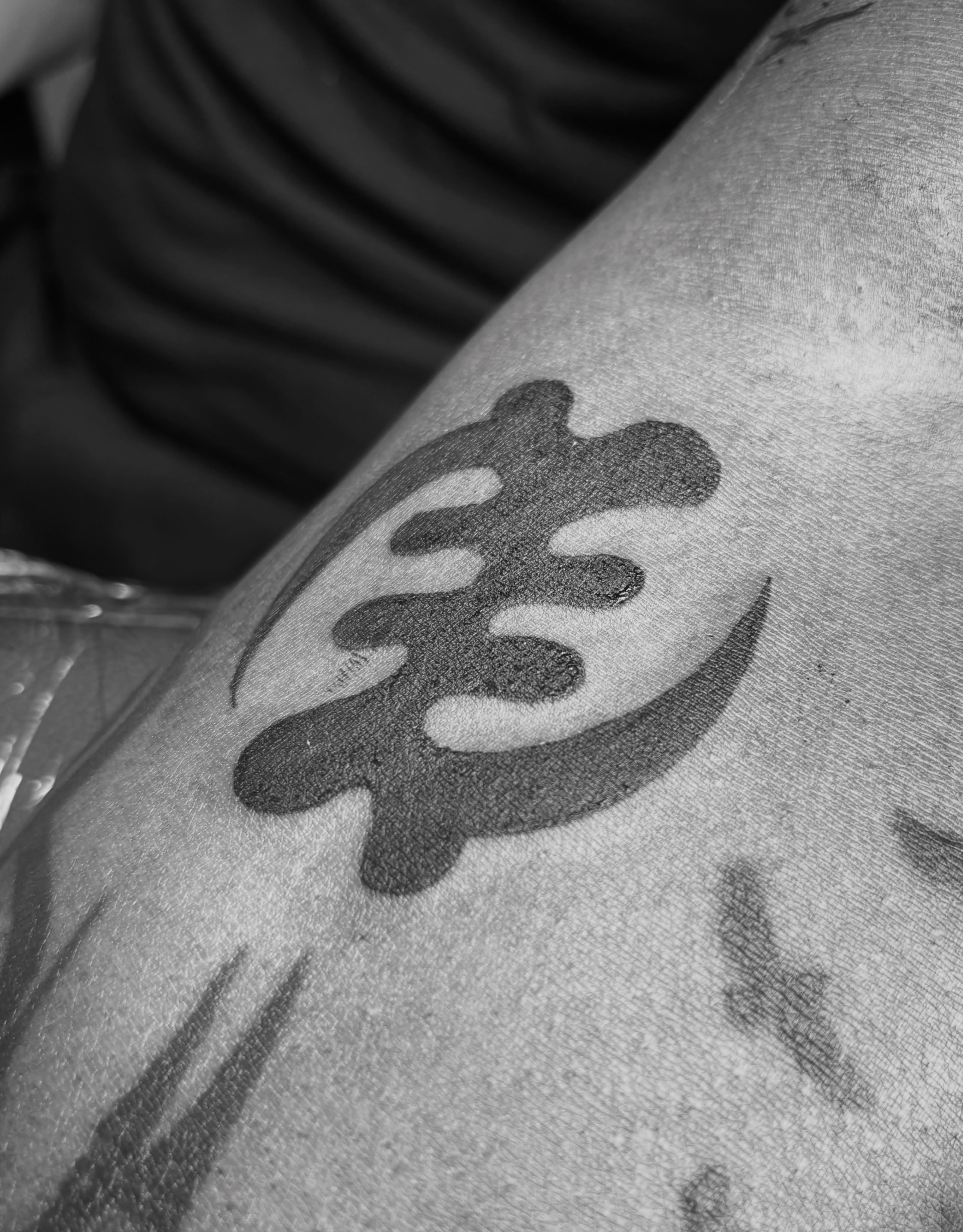 Calligraphy black and grey tattoo on the upper arm by @secretlinetattoo