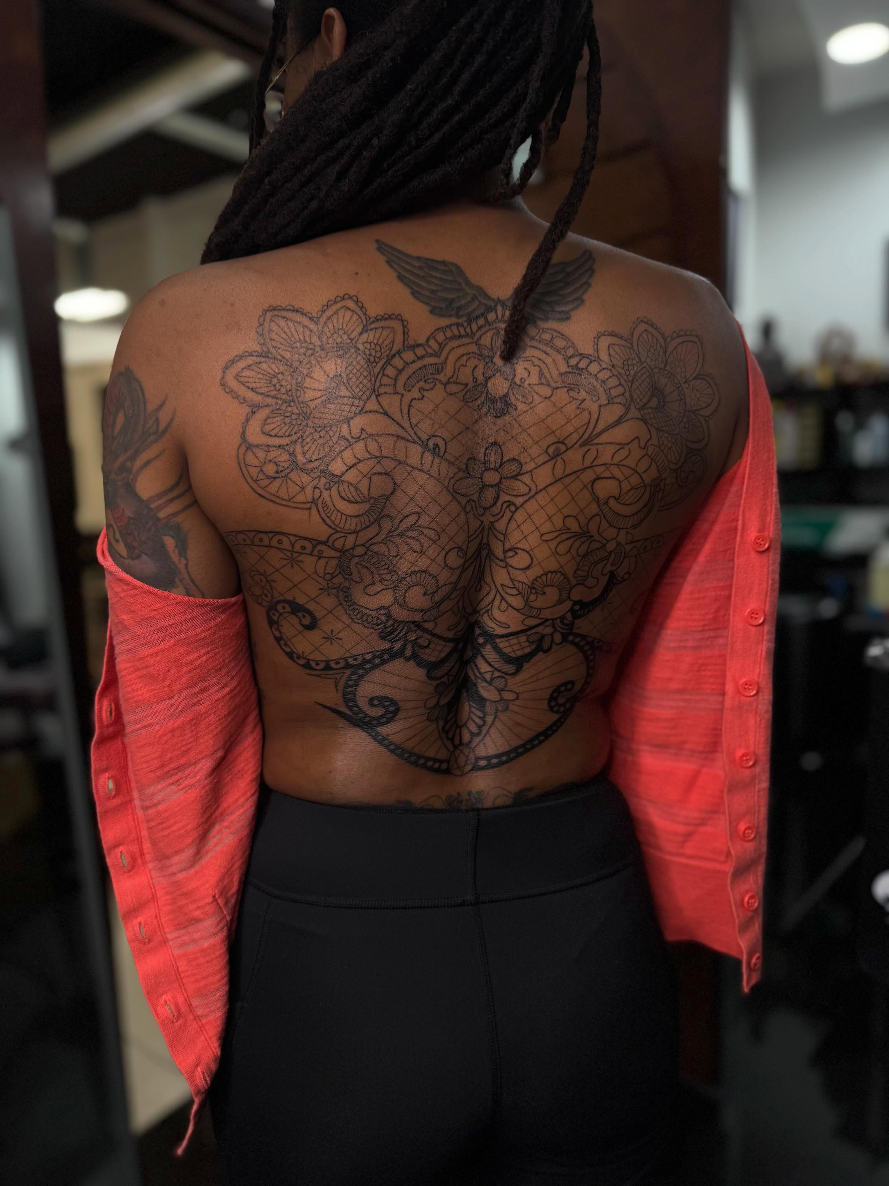 Floral and butterfly black and grey tattoo on the back by Idalia Pulido
