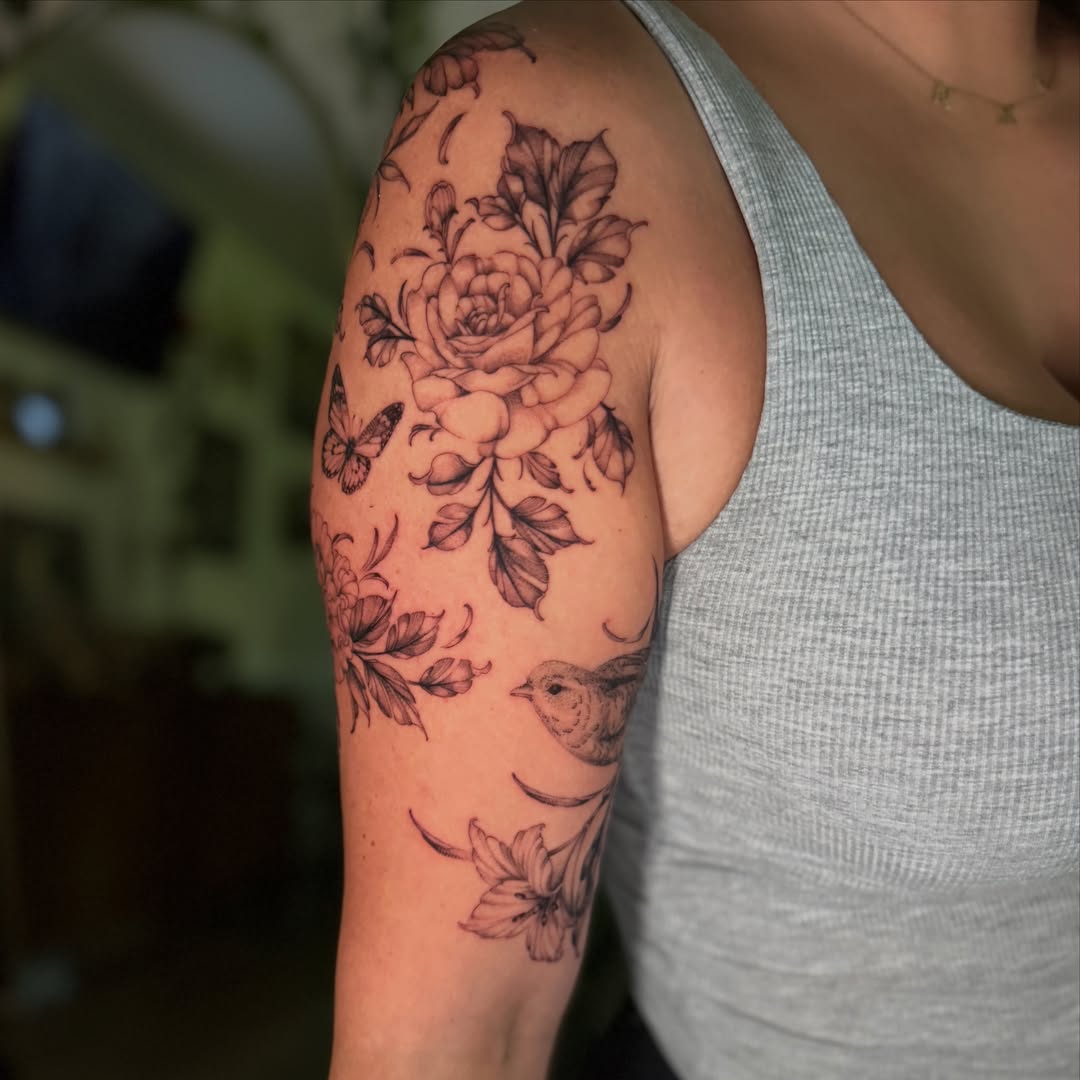 Floral bouquet black and grey tattoo on the upper arm by Chiah