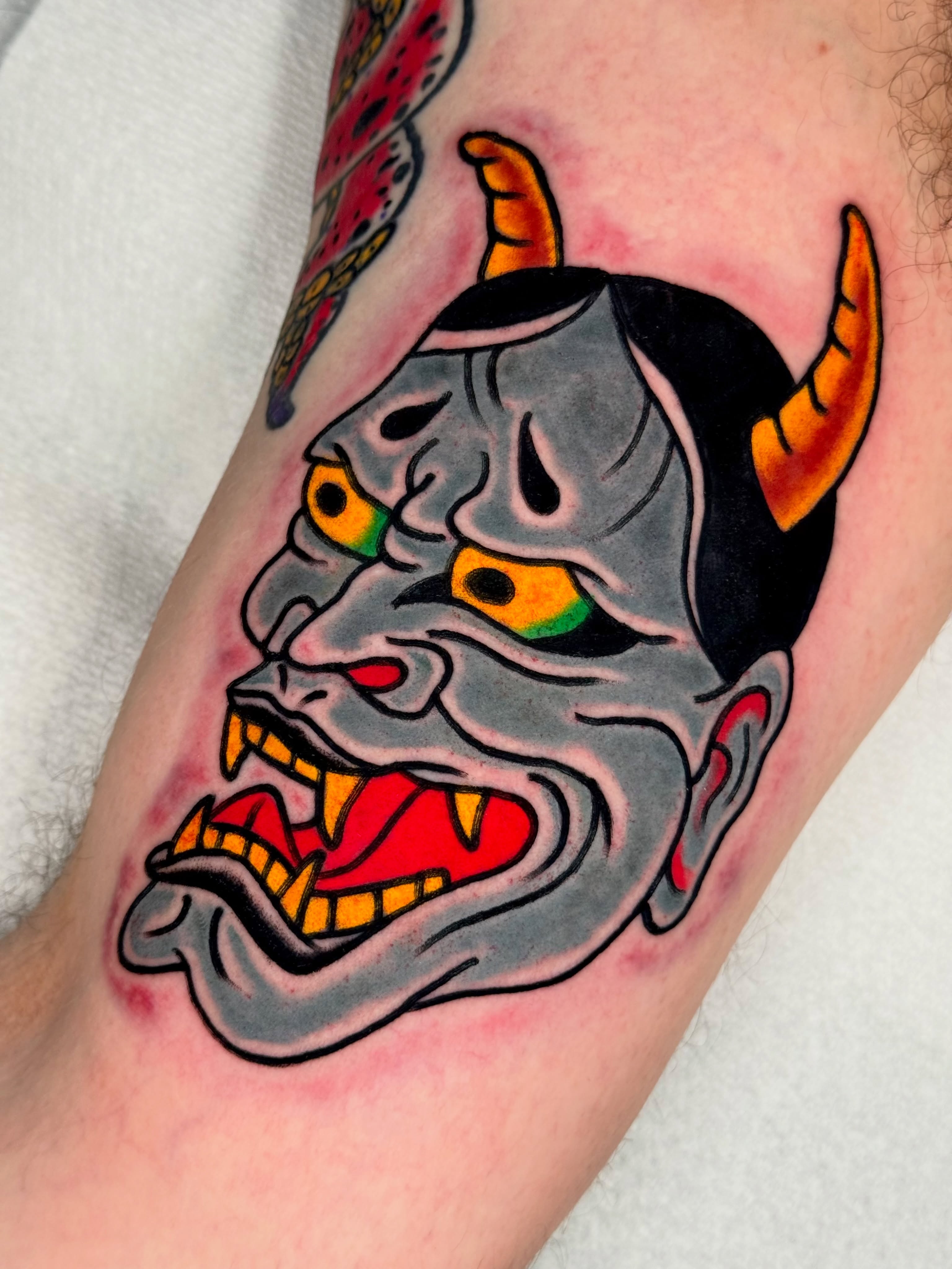 Demon mask American traditional tattoo on the forearm by Joe Bear Tattooer